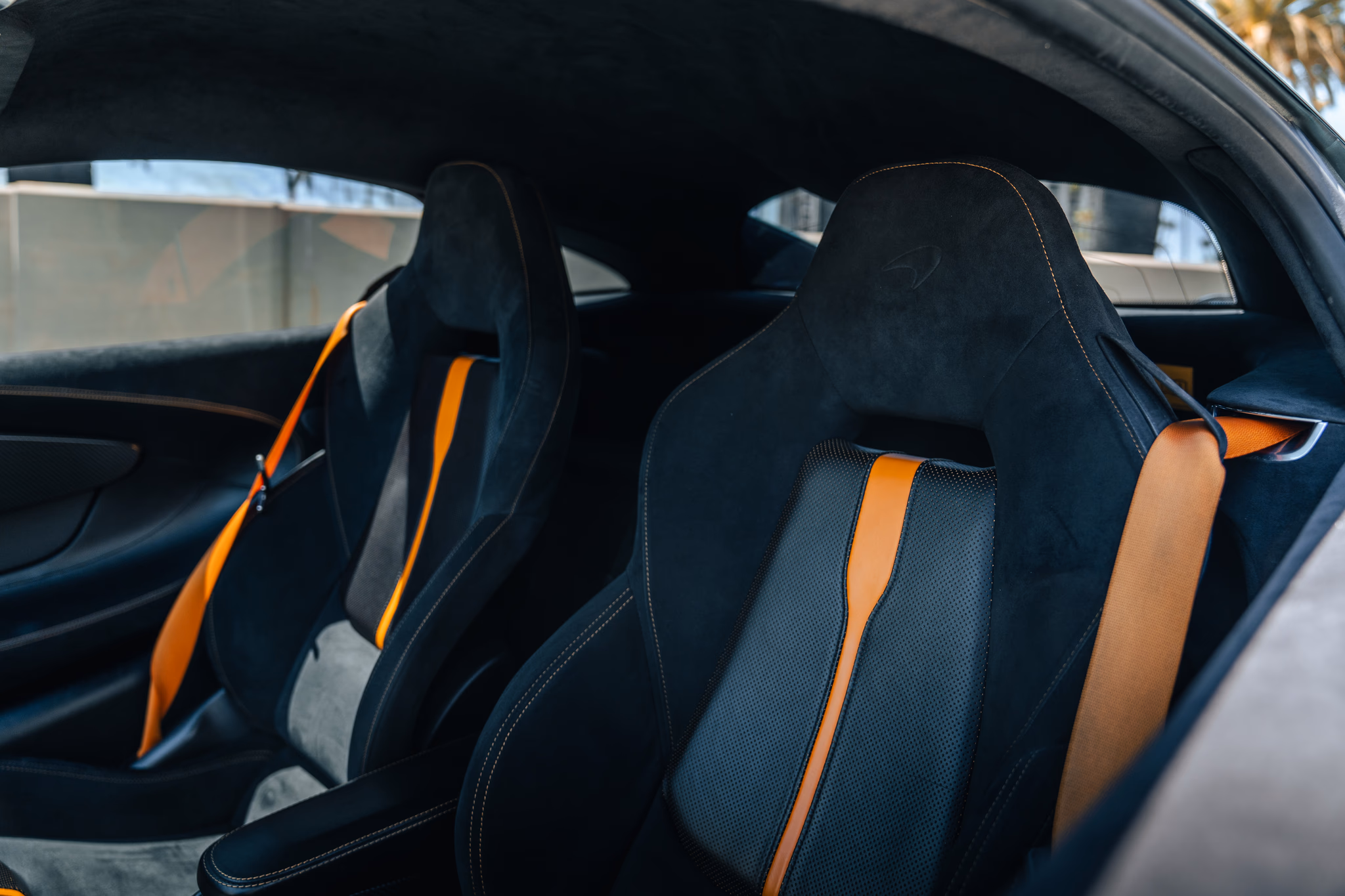 Black alcantara seats with orange center stripes inside the McLaren 570S coupe
