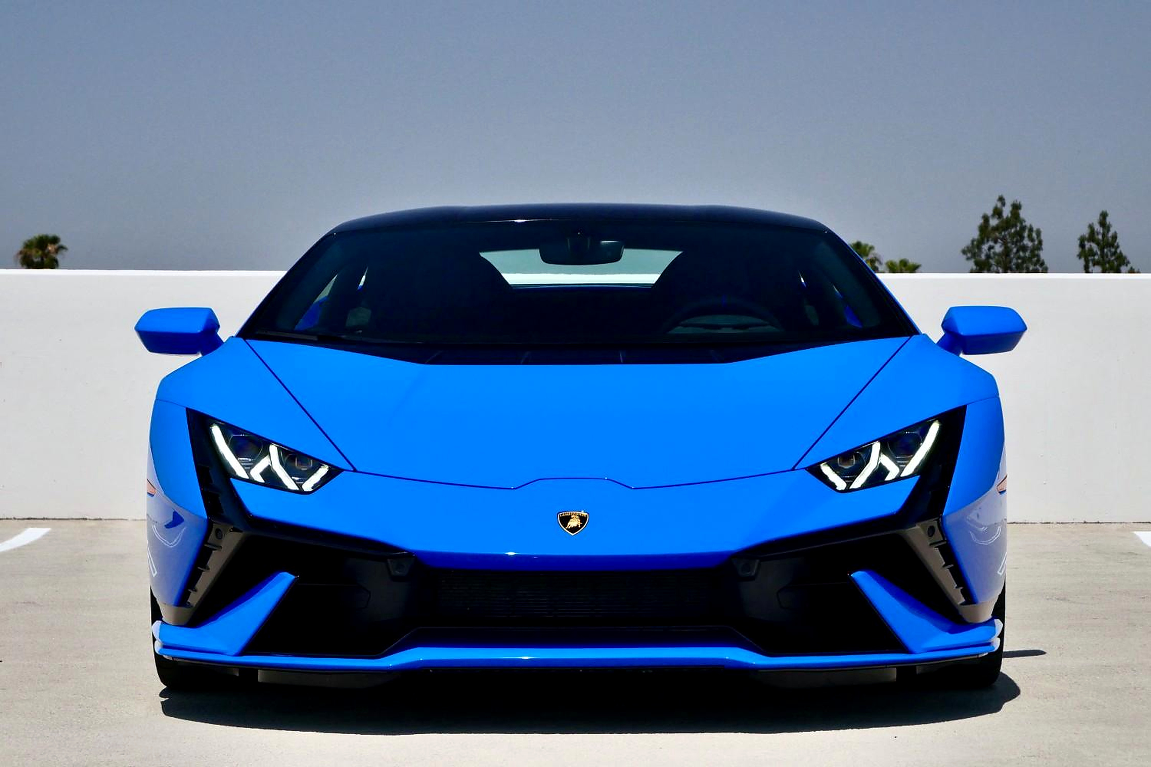 Head-on view of the bright blue Lamborghini Huracan Tecnica, Y-shaped headlights and low splitter