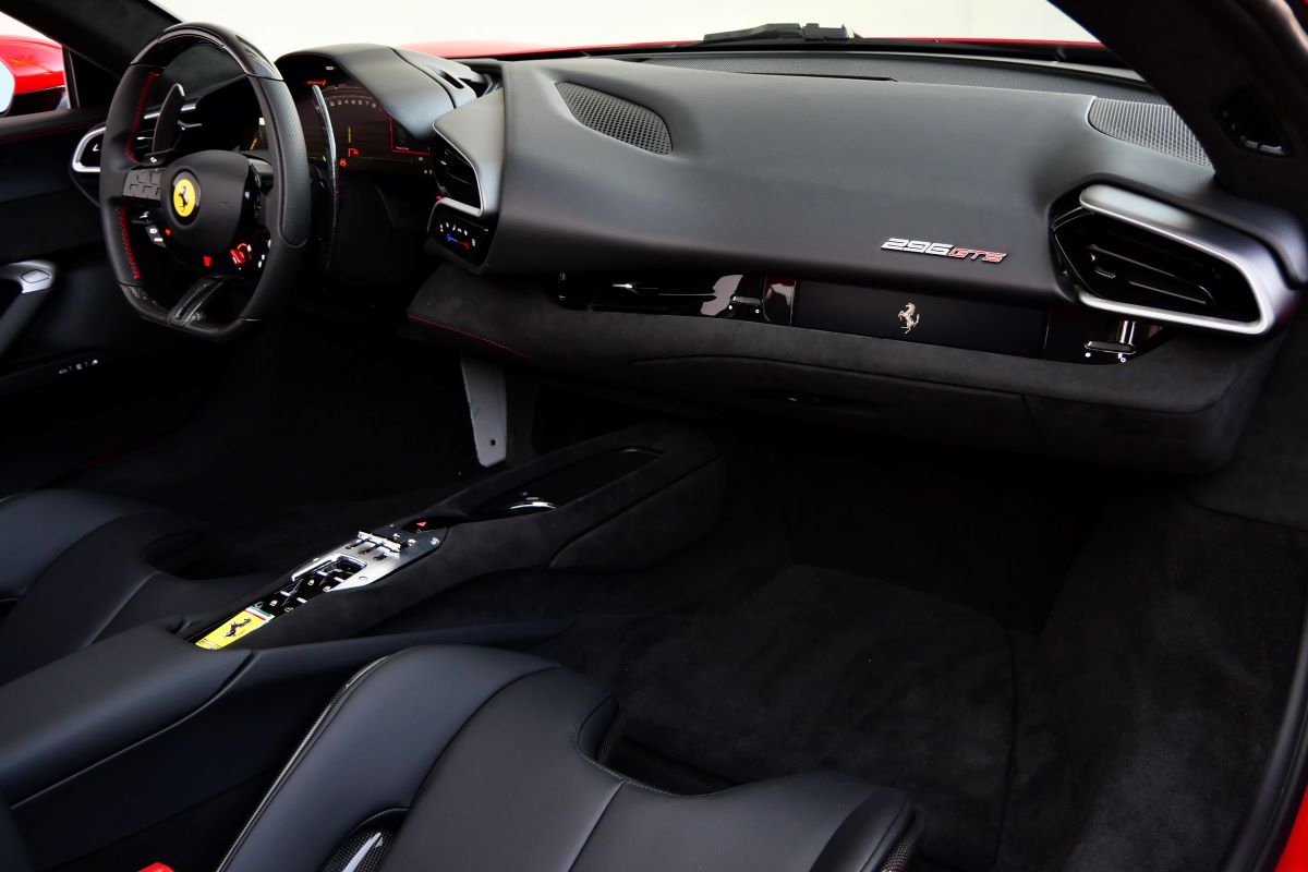 Passenger side of the 296 GTS dash in black Alcantara with the 296 GTS plate and the air vent