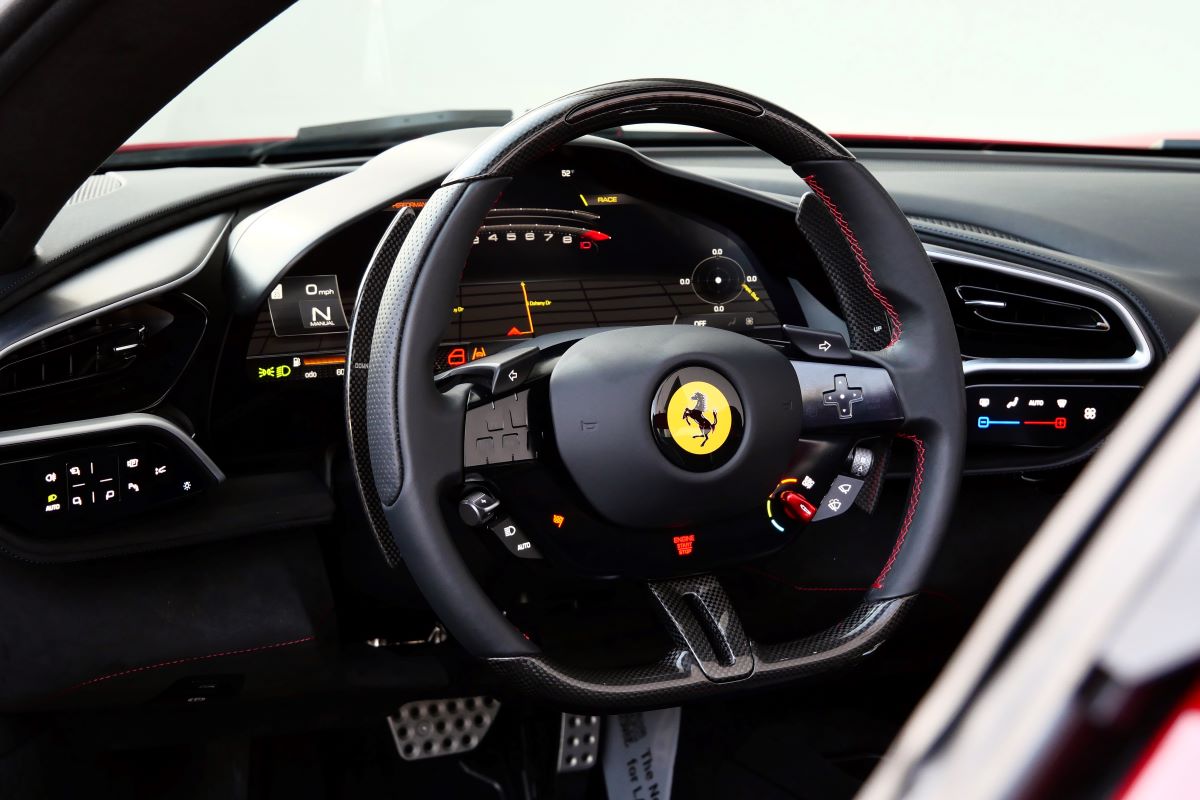 Driver's view of the 296 GTS steering wheel with the carbon top, shift lights and the curved digital display