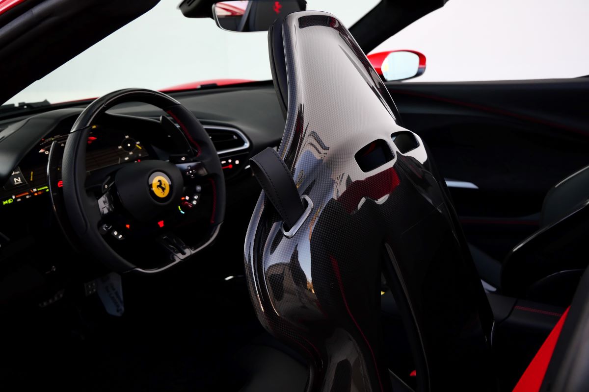 Open driver's door of the Ferrari 296 GTS showing the door panel and the steering wheel beyond