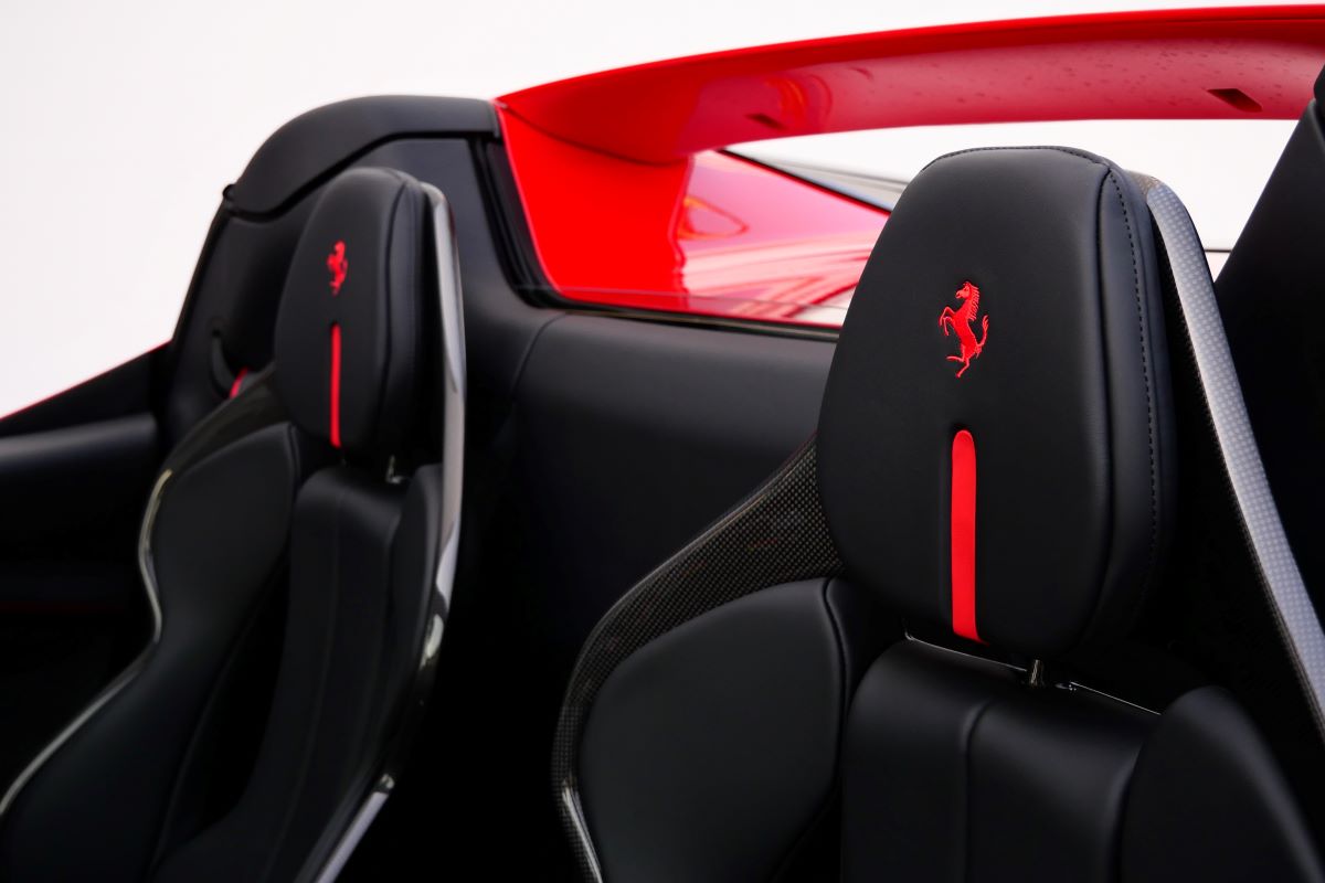 The 2 black seats of the red 296 GTS from behind, red centre stripes, carbon backs and a Cavallino in each headrest