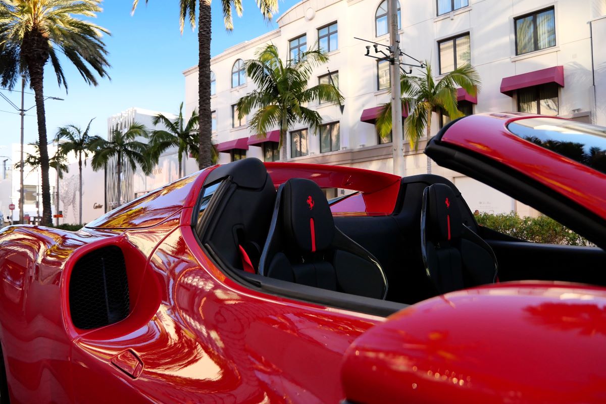 Rear deck of the red 296 GTS with the roof down, the 2 headrests and buttresses against a Beverly Hills street