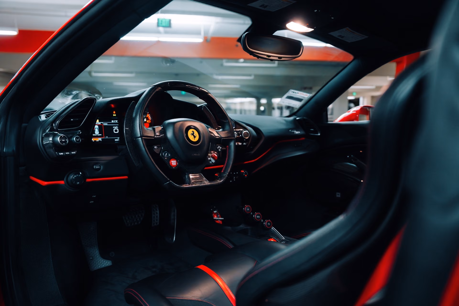 Inside the Ferrari 488 Pista, black Alcantara seats with red centre stripes and the steering wheel with the Cavallino