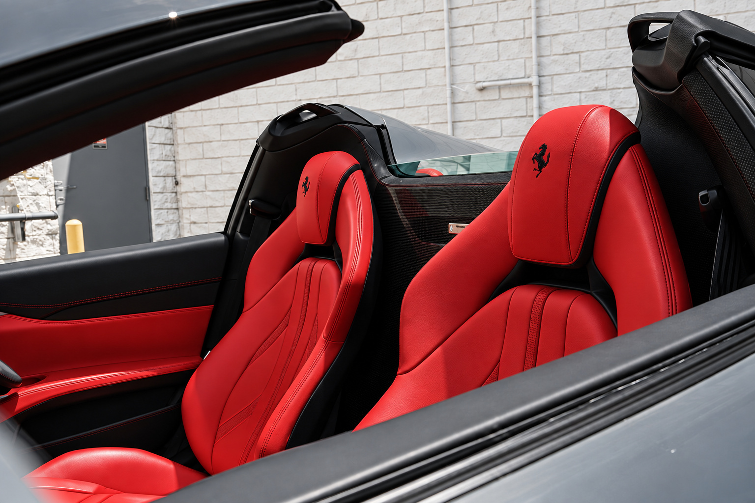 The 2 red leather seats of the 812 GTS from behind with a Cavallino stitched into each headrest