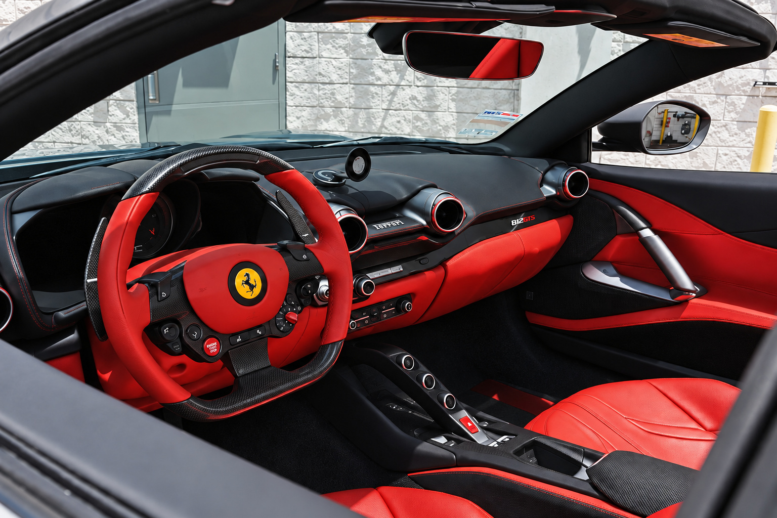 Driver's side of the 812 GTS cabin, red leather dash and doors, carbon steering wheel and the yellow Cavallino