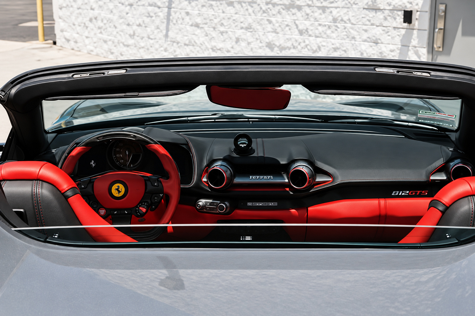 Looking through the open roof into the 812 GTS, red dash, red seats and the steering wheel with the Cavallino