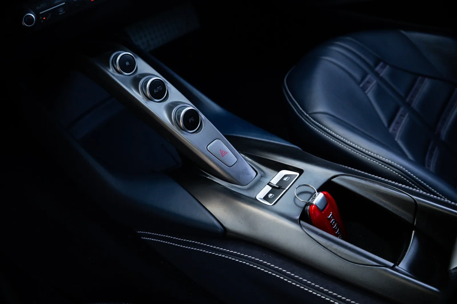 Centre console of the Ferrari 812 Superfast with the gearbox buttons and the edge of the black leather seat