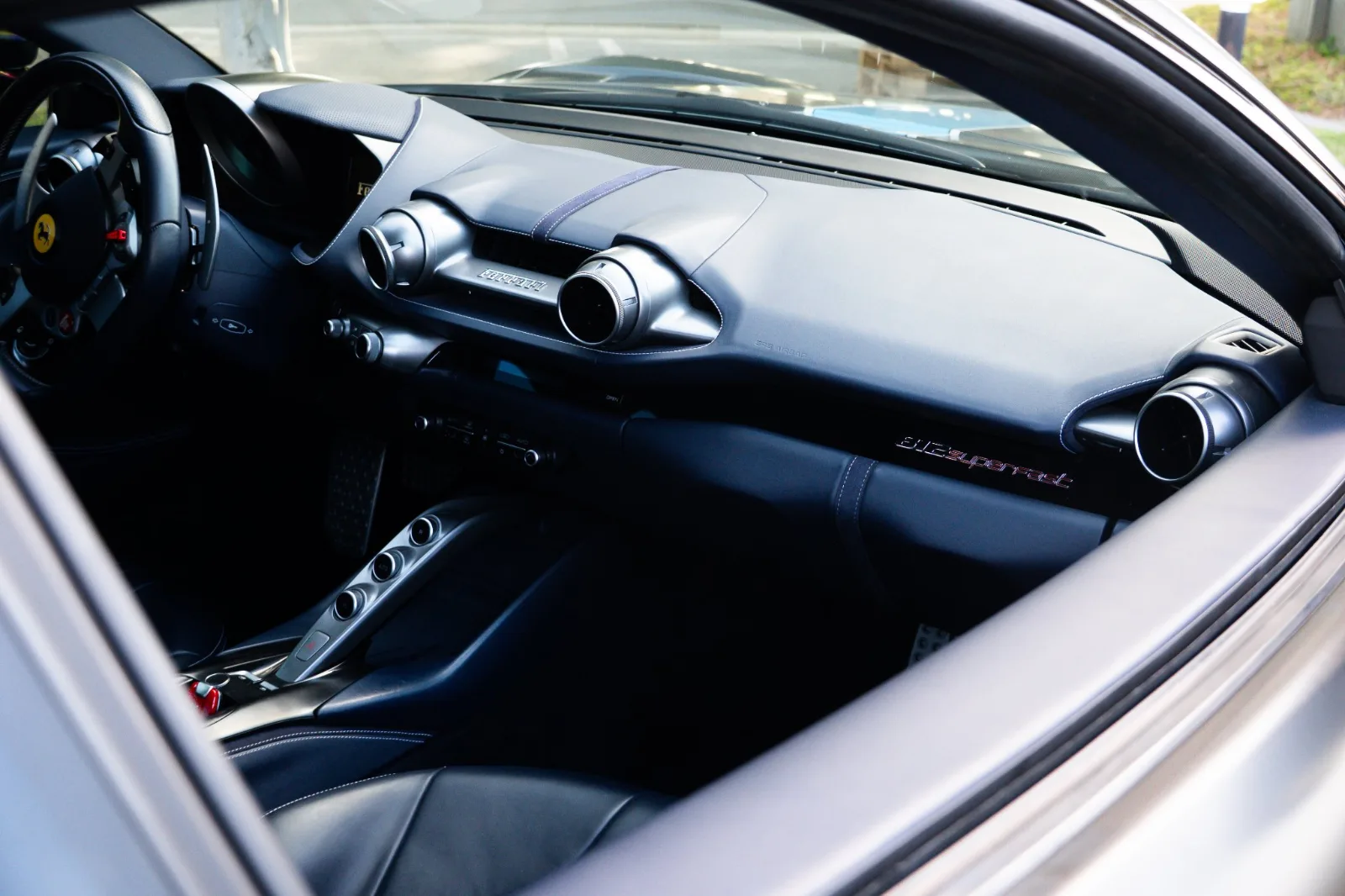 Passenger side dash of the 812 Superfast in black leather with the round vents and the Cavallino badge