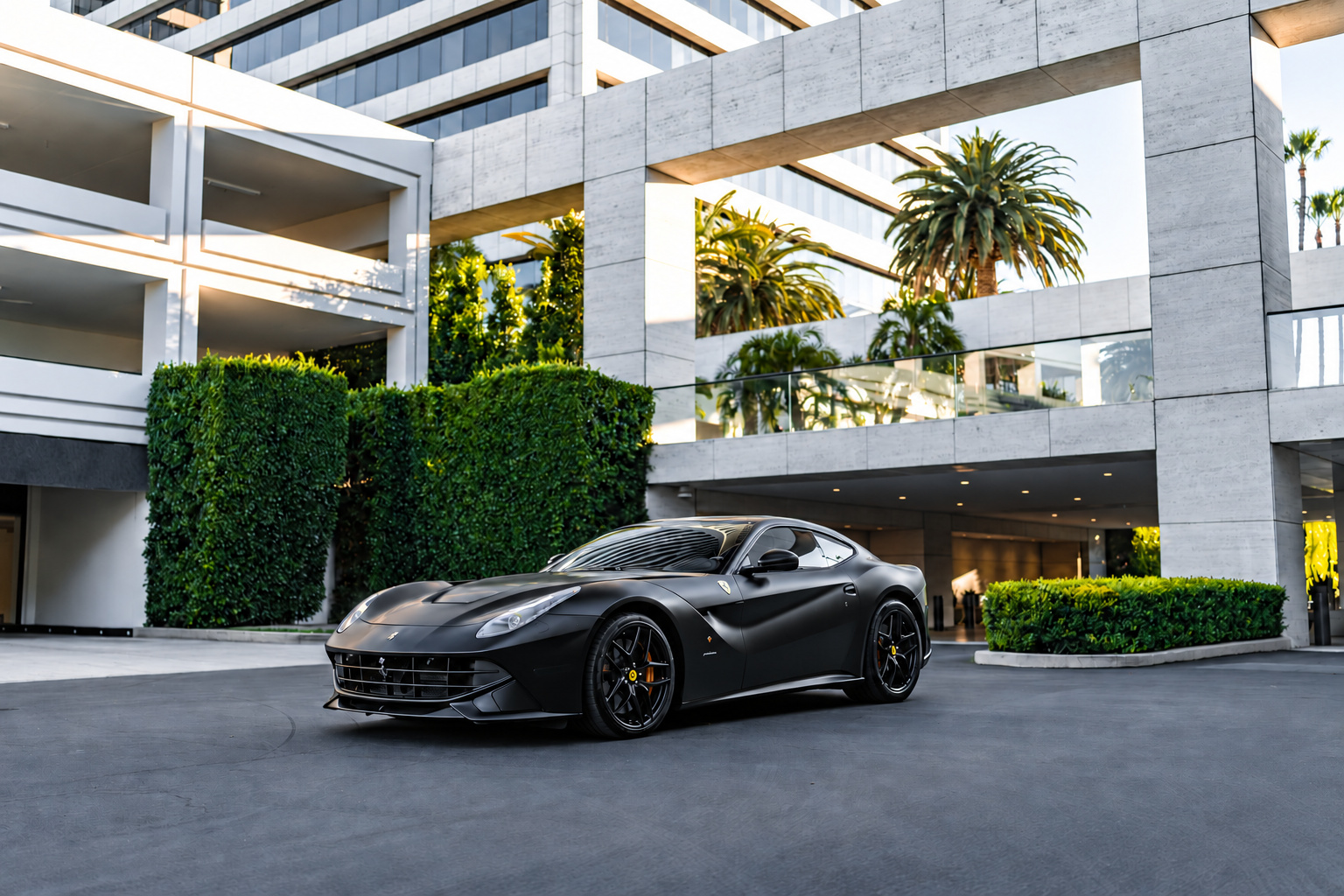 Satin black Ferrari F12berlinetta, front three-quarter view, a 730 hp V12 coupe to rent in Southern California