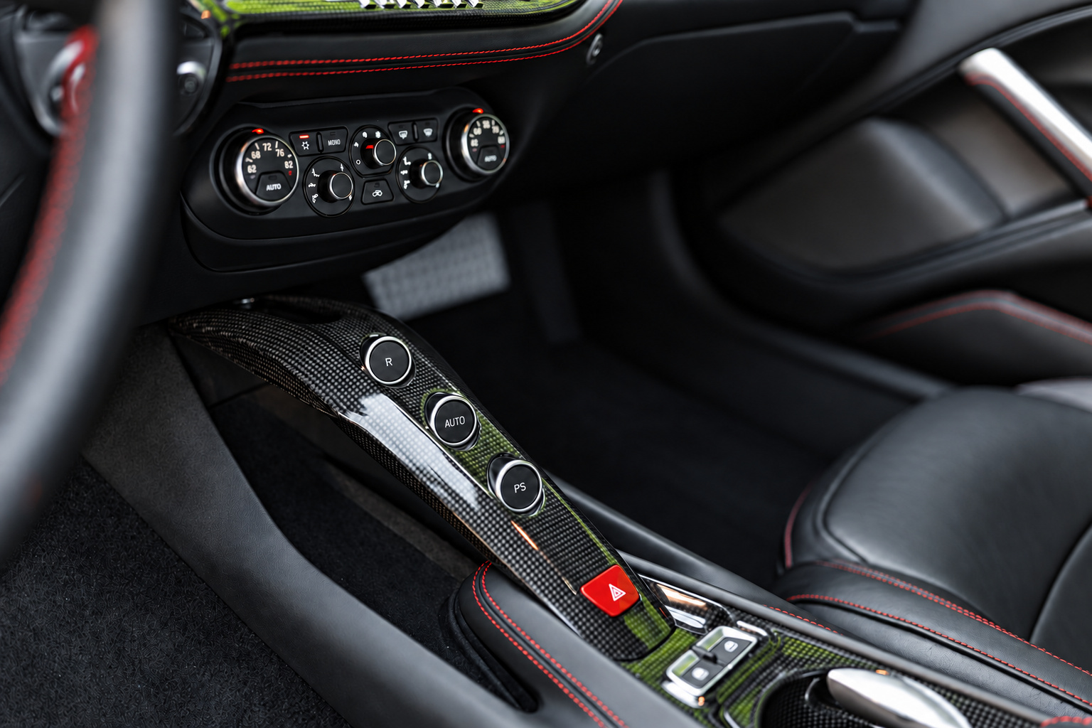 Carbon centre bridge of the Ferrari F12berlinetta with the gearbox buttons and the red stitched seat beside it
