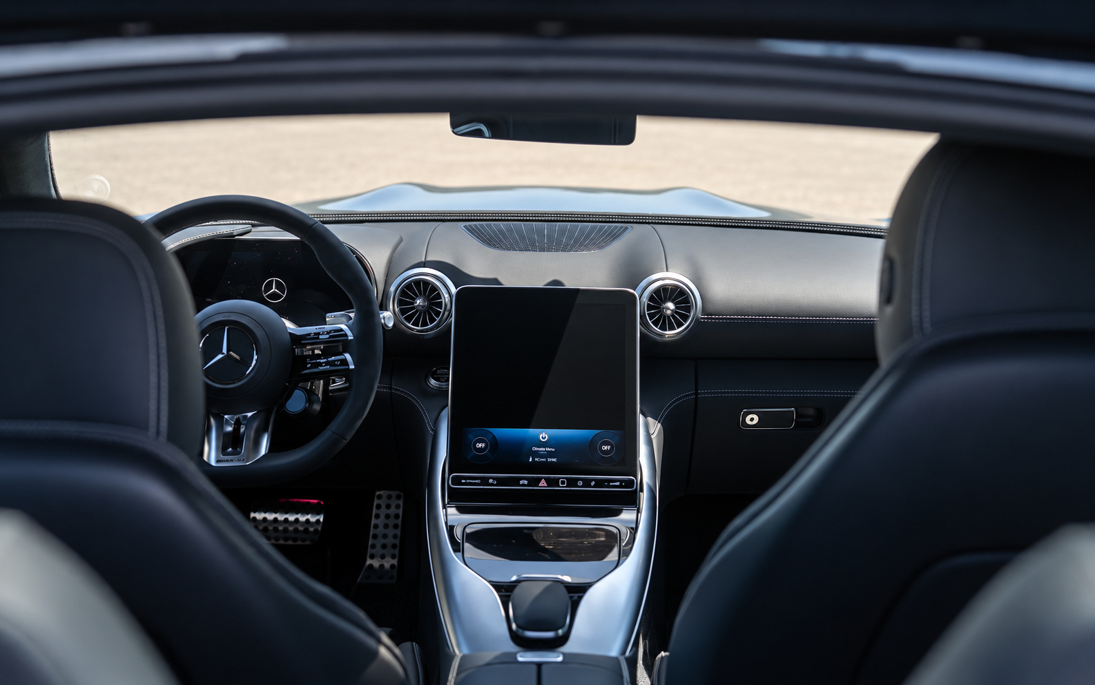 View from the back seat of the AMG GT 43 across the black cabin to the portrait screen and round air vents