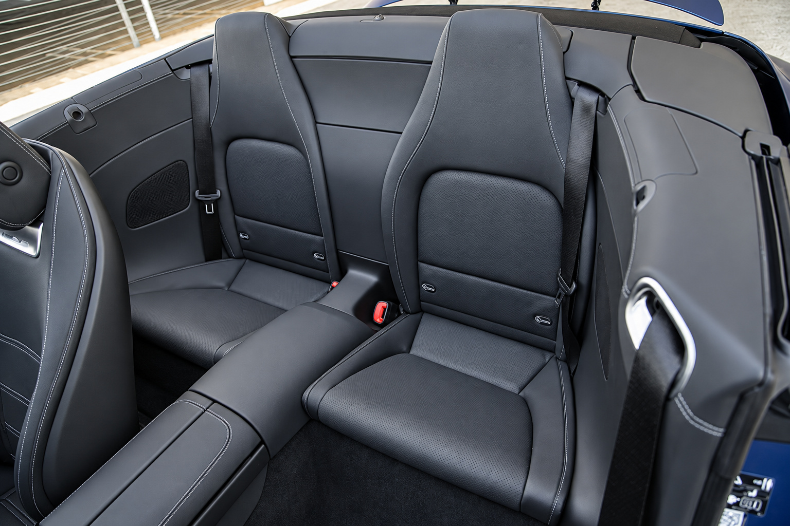 Rear 2+2 seats of the Mercedes-Benz AMG SL rental in black leather, seen from above with the roof down