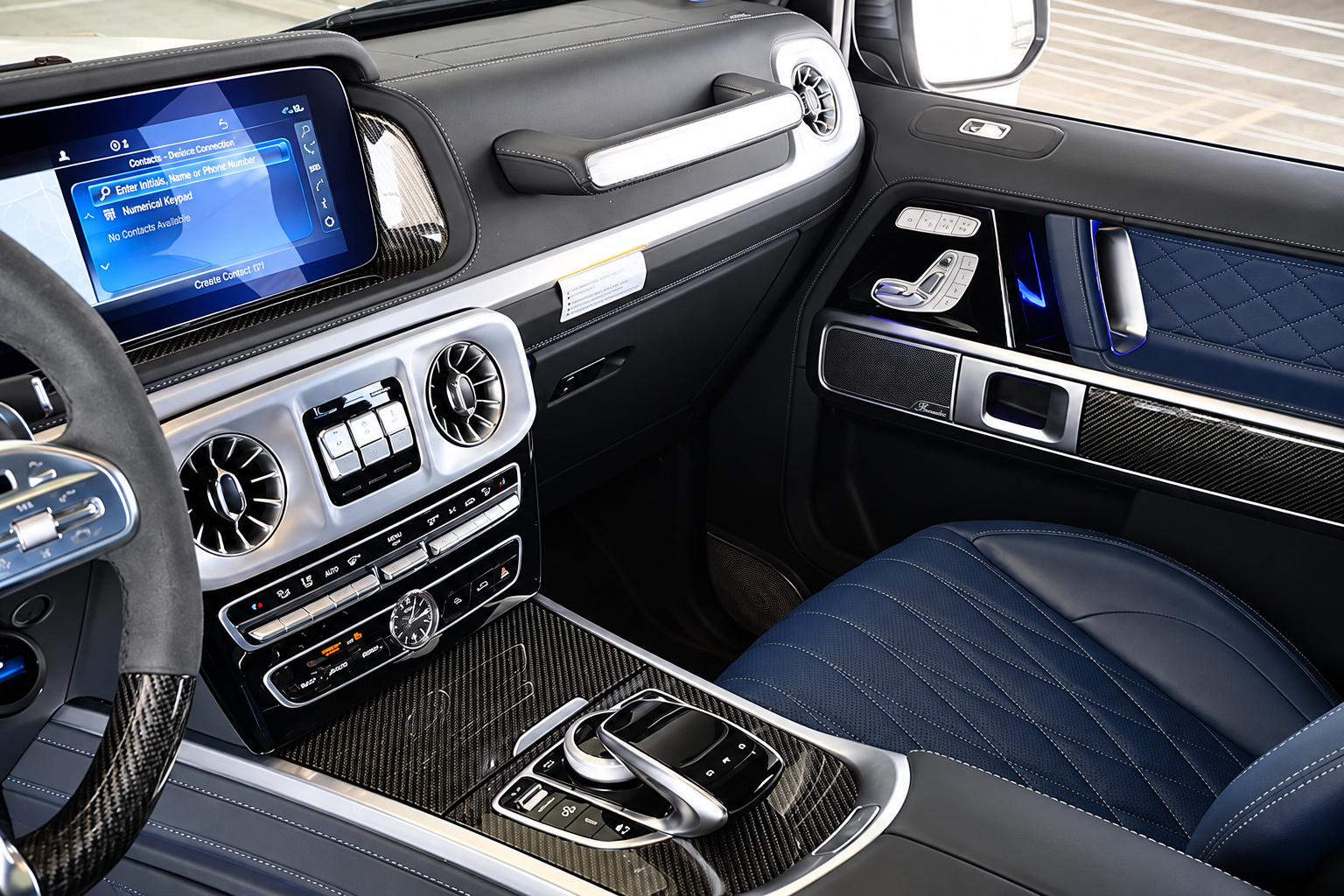 Passenger side of the G63 dash, blue quilted leather, carbon fibre trim, centre screen and the grab handle