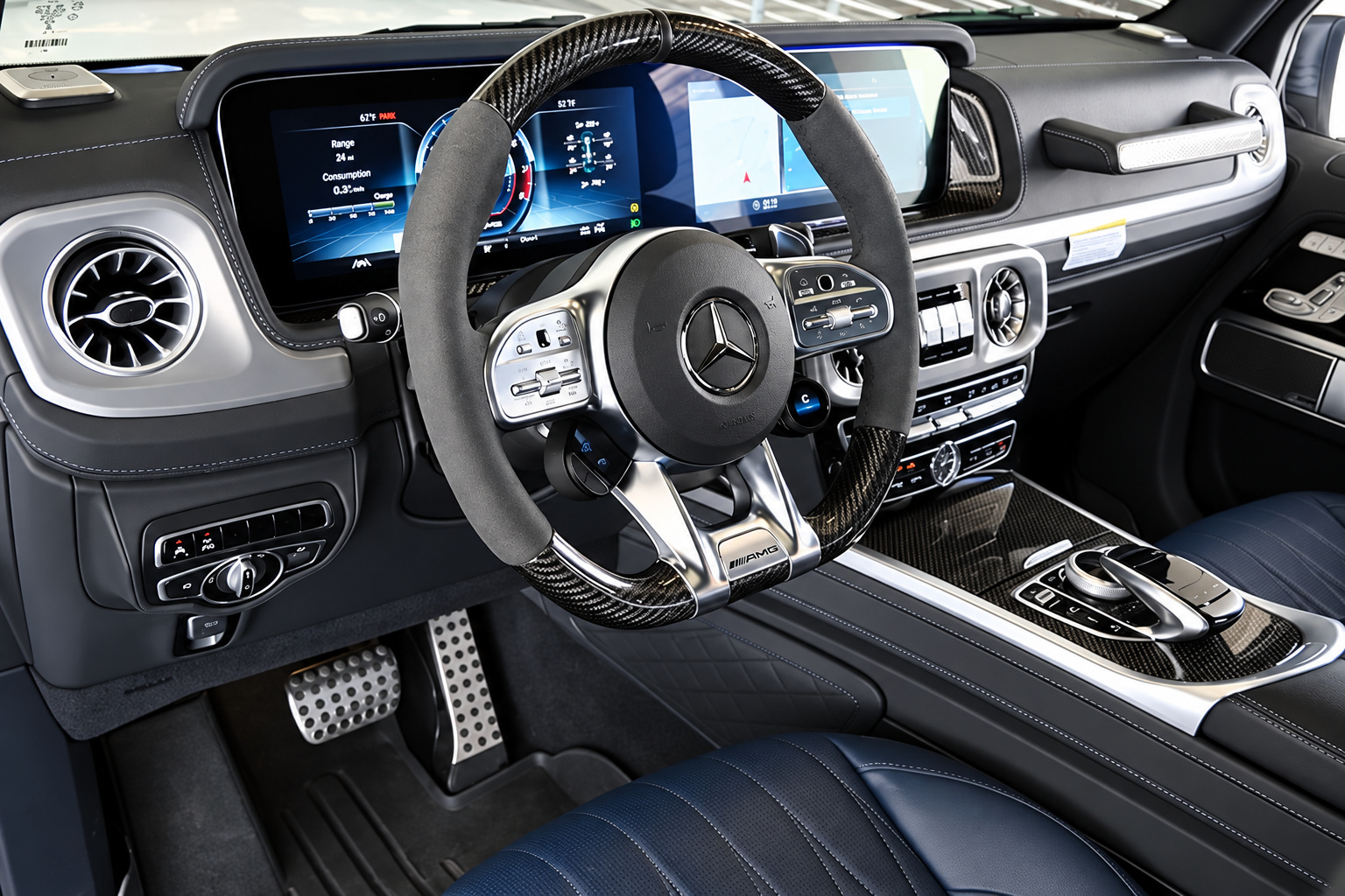 AMG steering wheel of the G63 with carbon fibre spokes, twin-screen dash and AMG pedals in blue and black