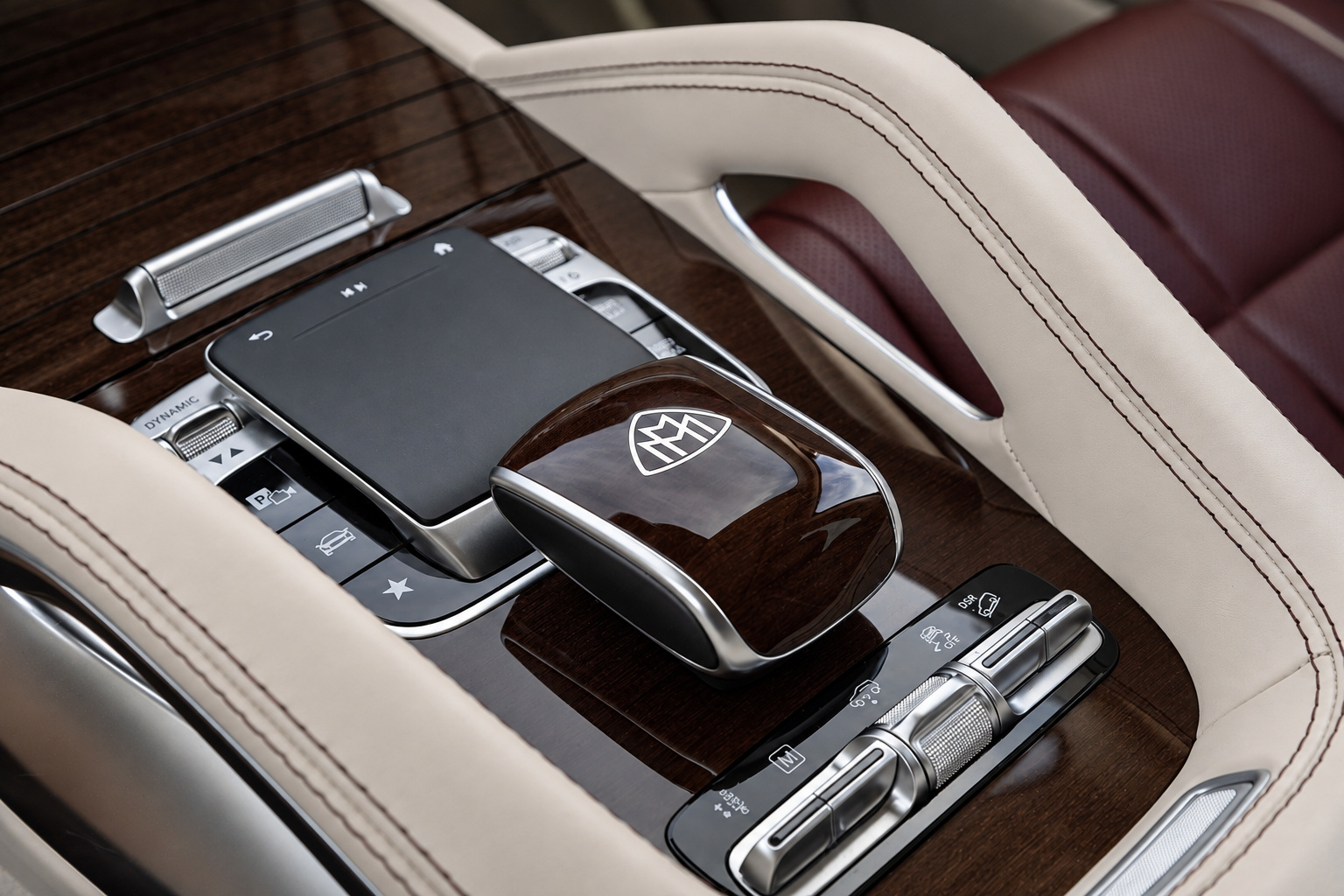 Rear console of the Maybach GLS 600 with the docked Maybach tablet, wood trim and cream leather seat controls