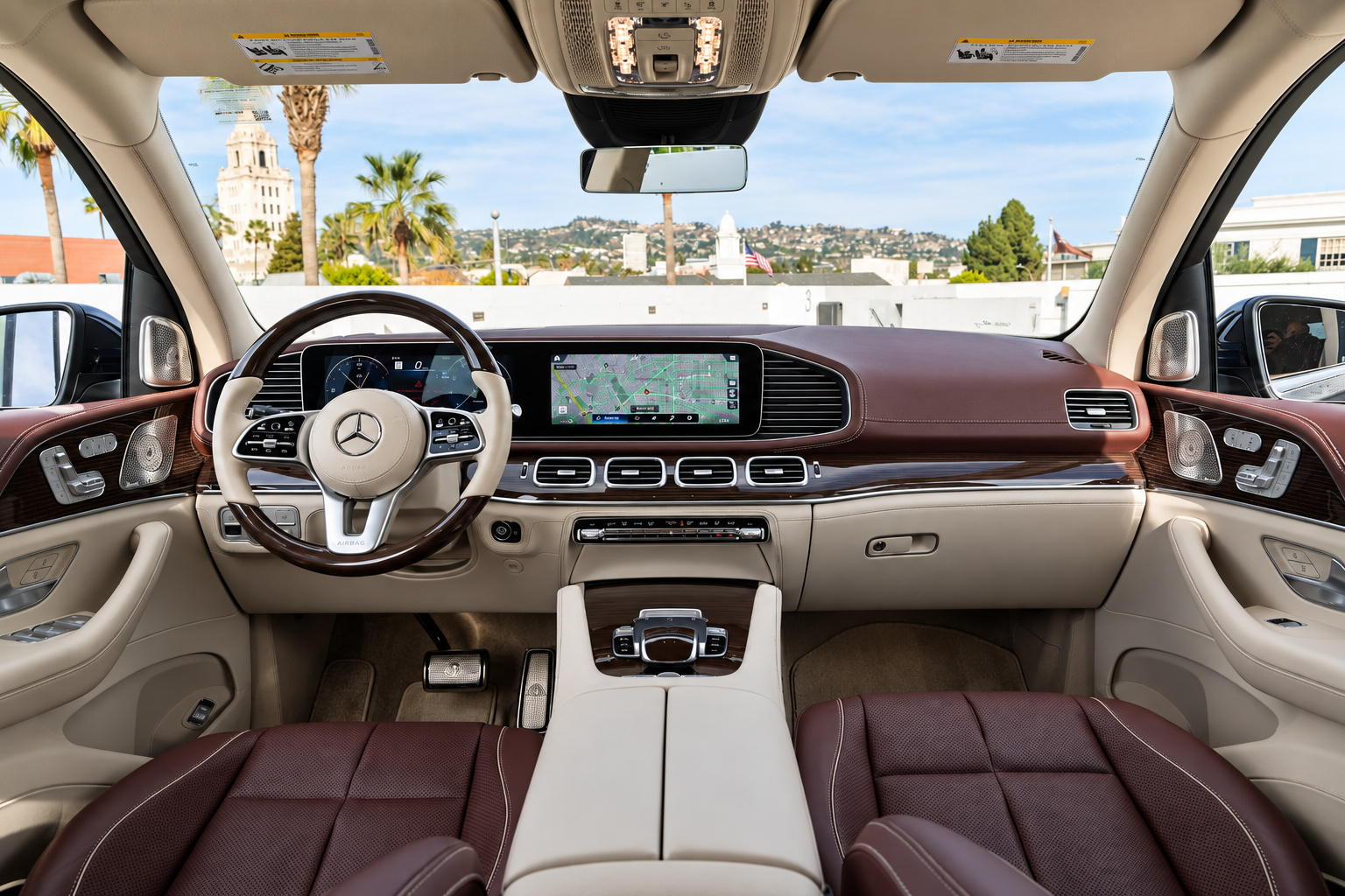 Dash of the Maybach GLS 600 from the back seat, cream dash top, brown seats and twin screens with Beverly Hills outside