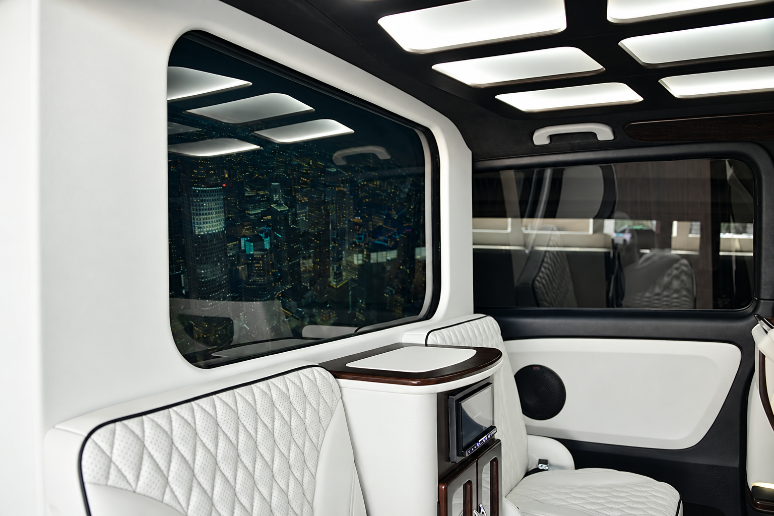 Side wall of the Mercedes-Benz Metris rental lounge cabin, wood-trimmed screen and quilted panels
