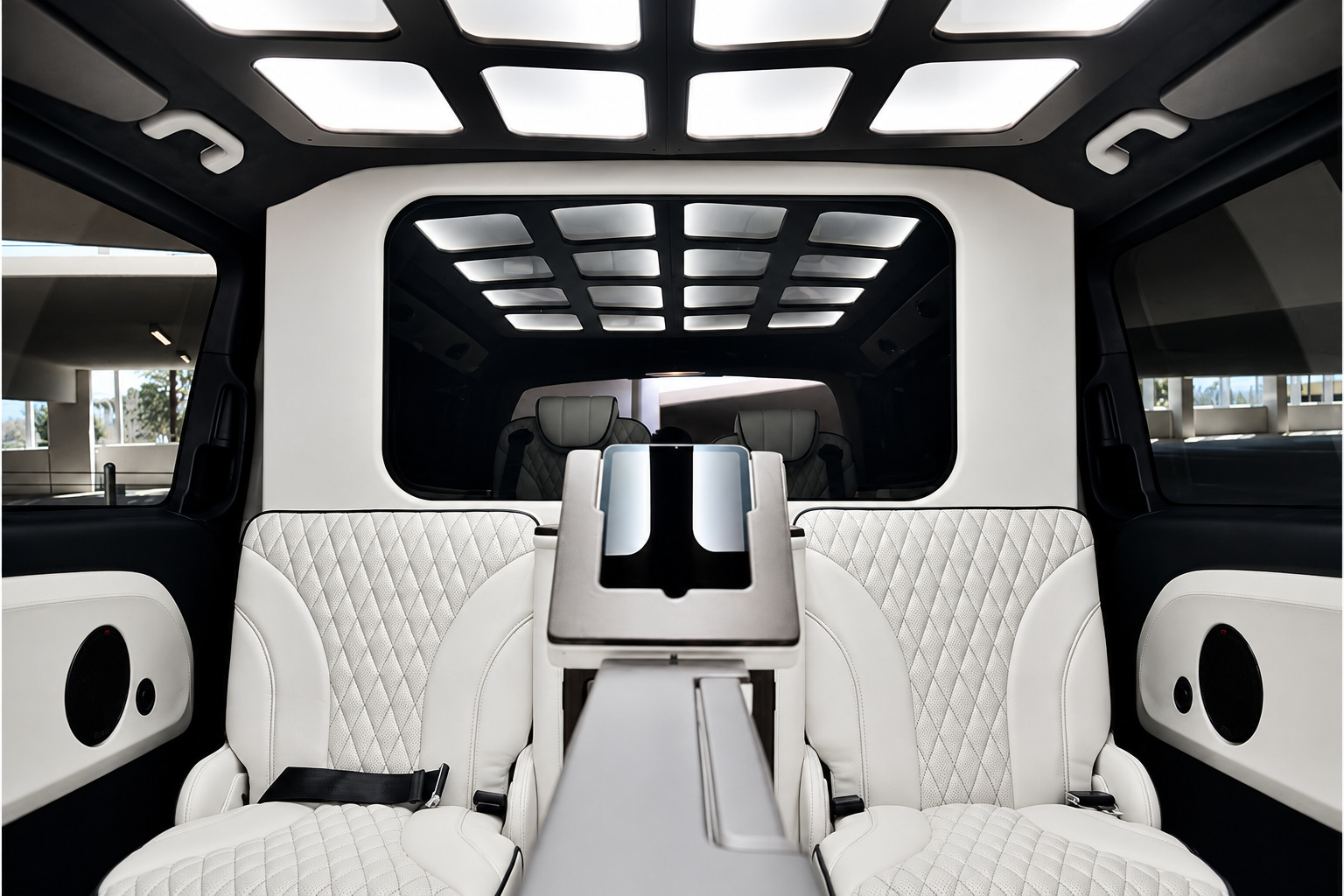 View forward from the rear bench of the Mercedes-Benz Metris rental, white seats and the full lit ceiling