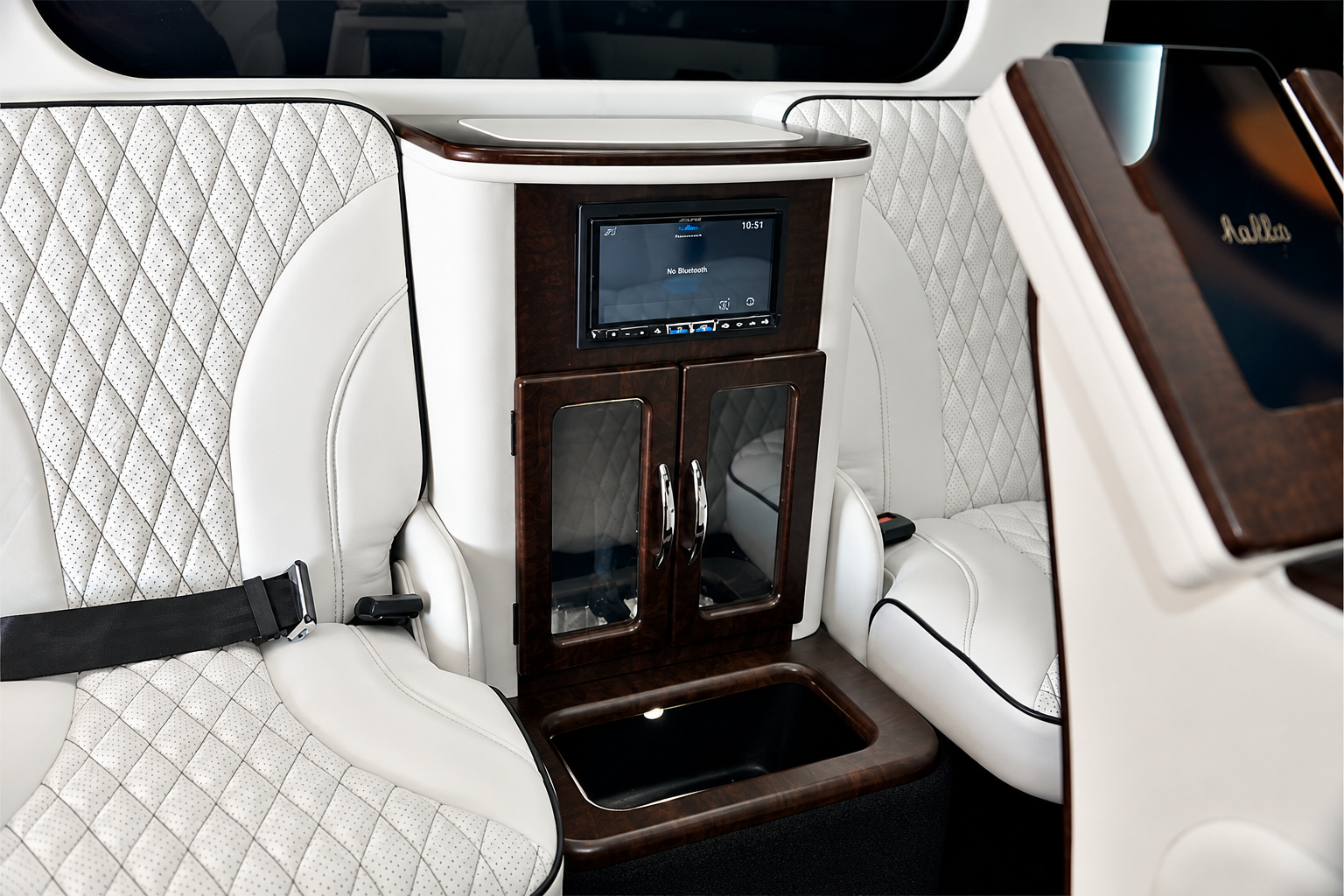 Wood rear console of the Mercedes-Benz Metris rental with a screen and glass-fronted cabinet