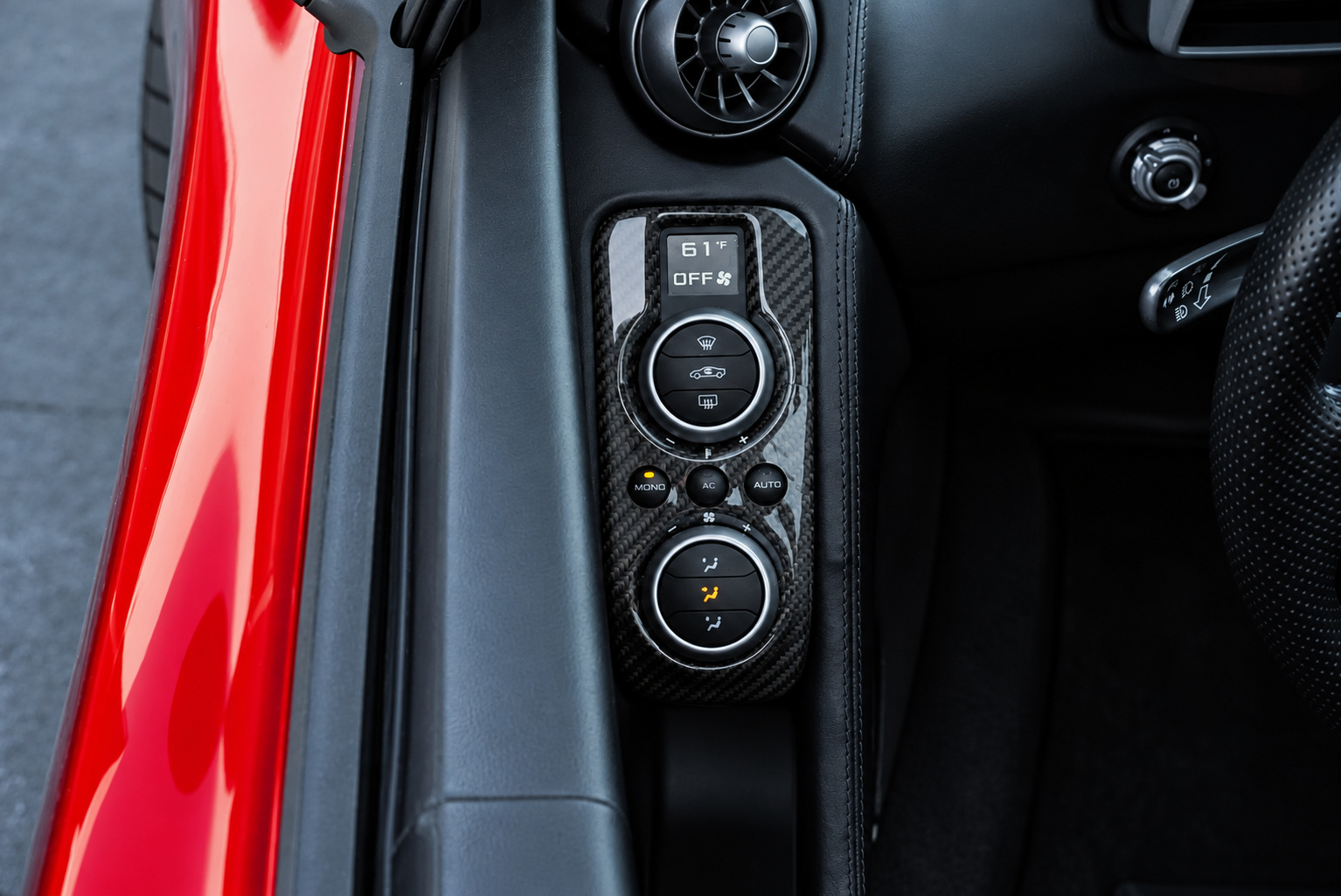 Carbon fiber door switch panel inside the red McLaren 650S Spider, window and mirror controls