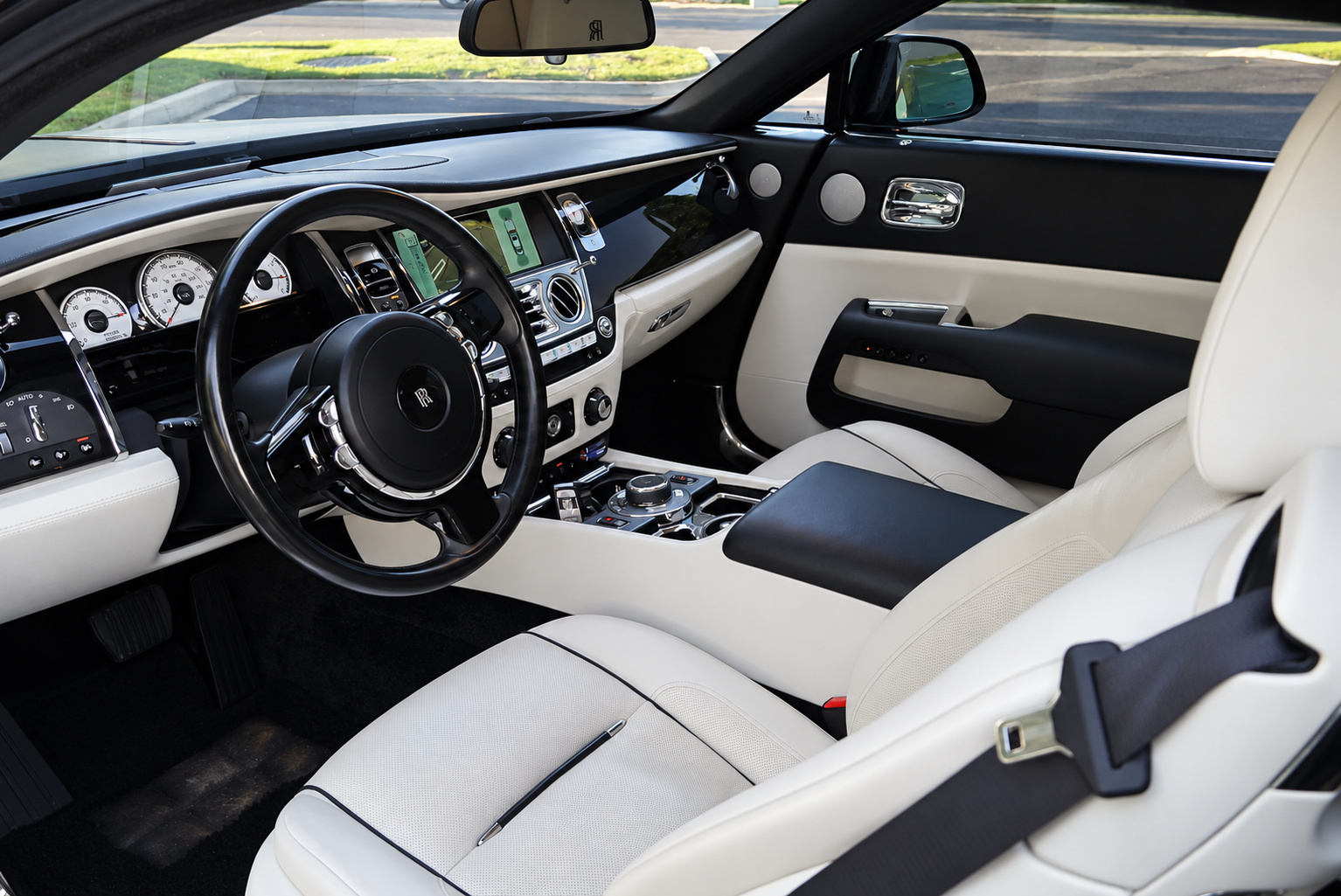 Driver's view of the black Wraith cabin, ivory leather, black dash top and the Rolls Royce dials