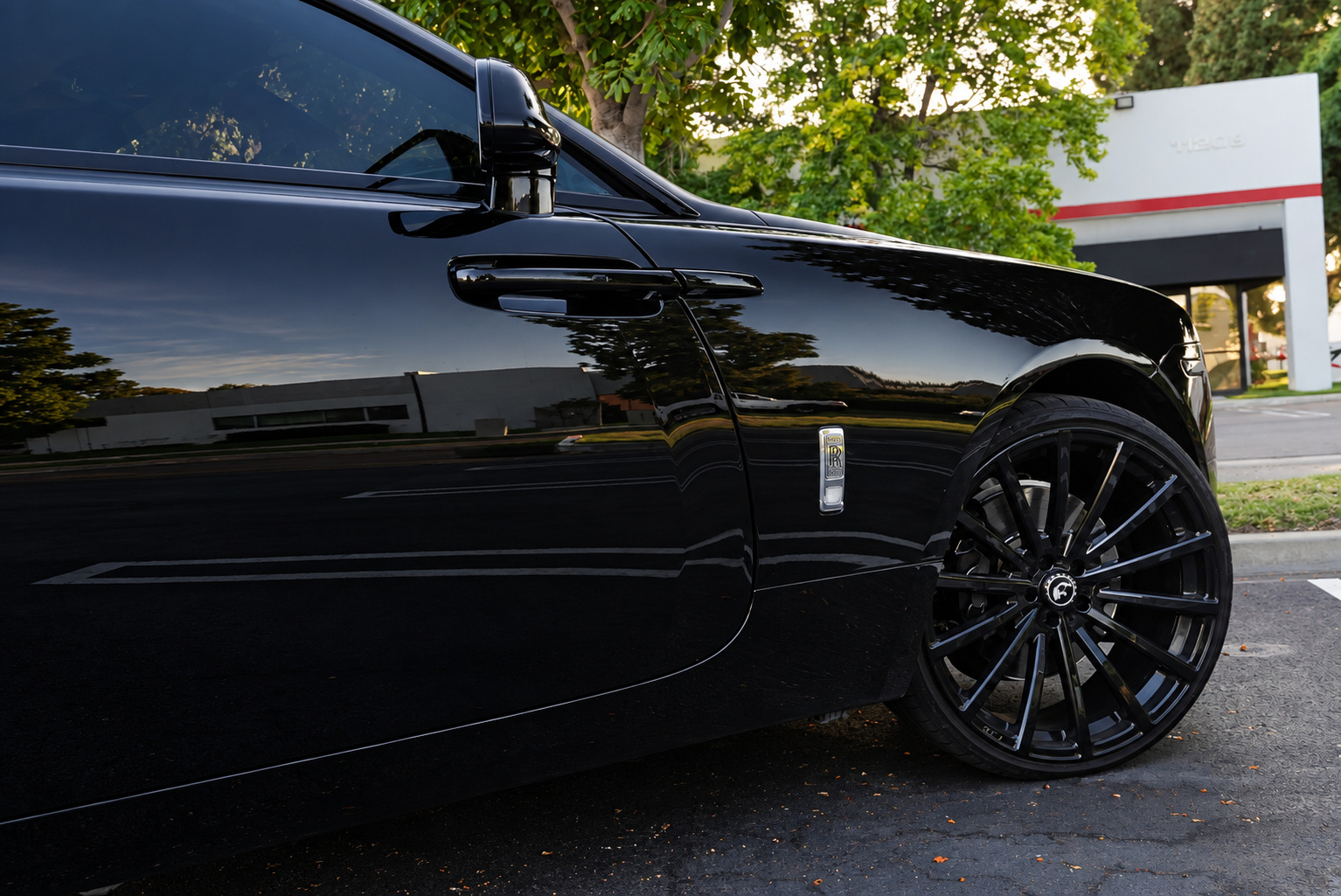 Side detail of the Wraith's long rear-hinged coach door and gloss black 21-inch multi-spoke wheel