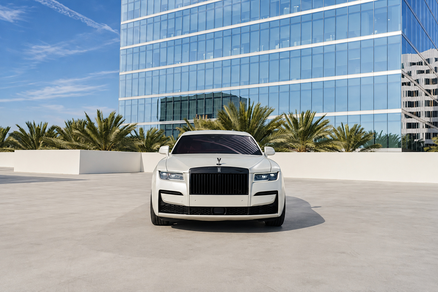 Head-on view of the white Rolls Royce Ghost with the blacked-out Pantheon grille and black wheels