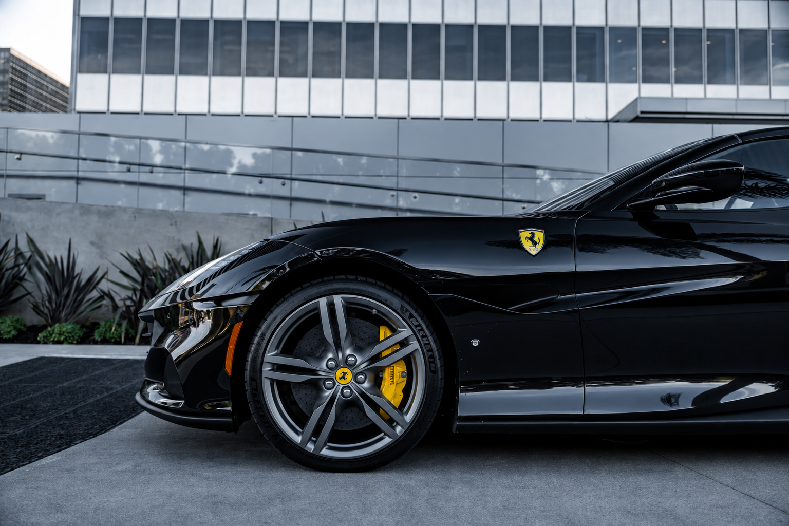 Front wheel and fender of the black Portofino, yellow caliper behind the silver wheel and the Scuderia shield