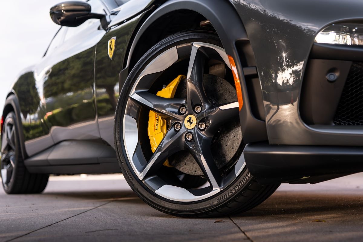 Front wheel of the grey Purosangue, dark 5-spoke rim with the yellow caliper and the Cavallino centre cap