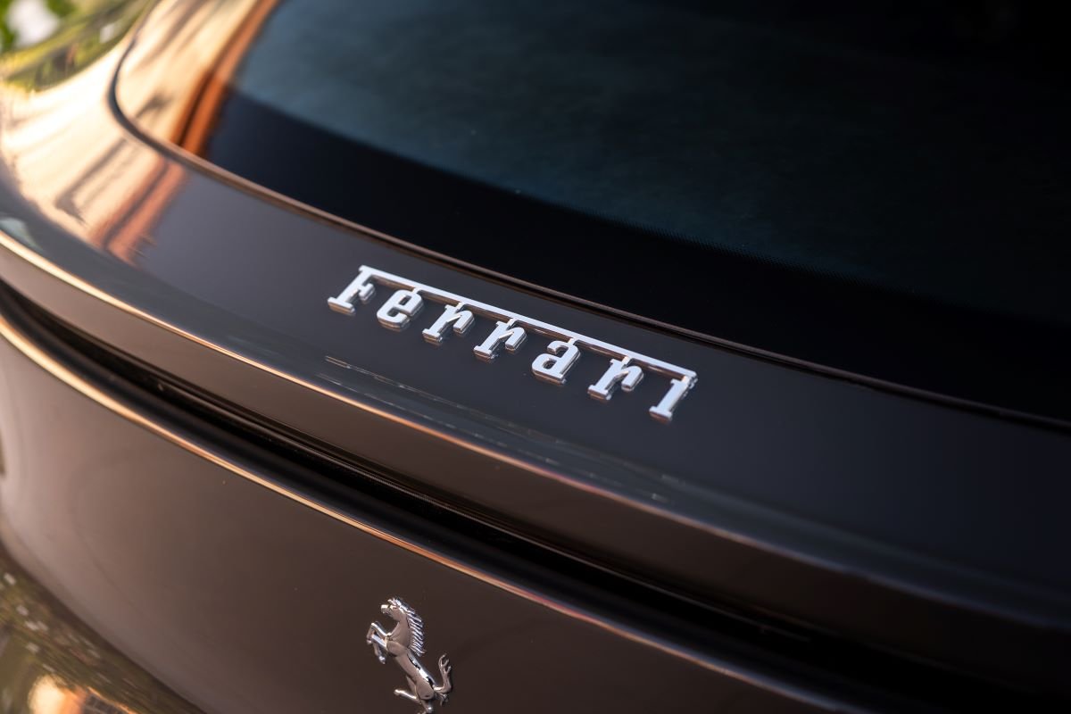 Ferrari script on the dark grey tailgate of the Purosangue with the Cavallino below it