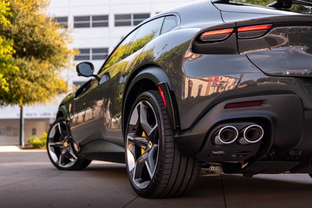 Rear quarter of the dark grey Purosangue, tail light, quad exhaust tips and the dark wheel
