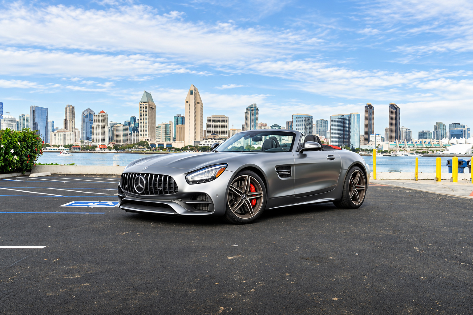 Satin silver Mercedes-Benz AMG GT C Roadster, top down, front three-quarter on the San Diego bayfront with the skyline