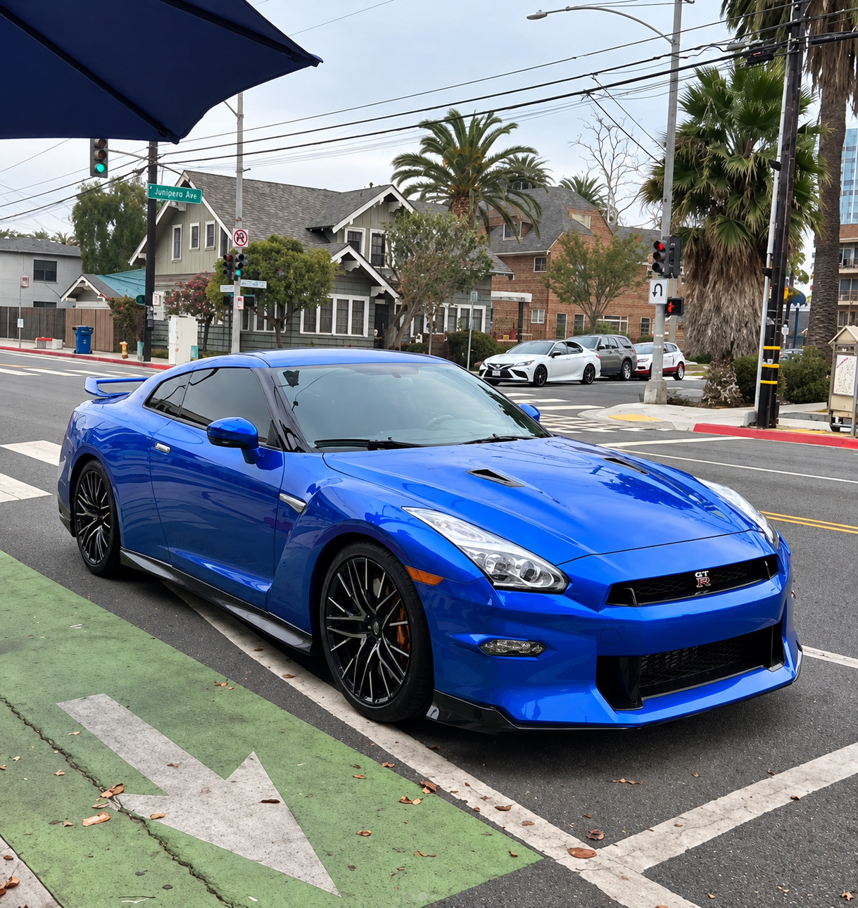 Bayside Blue Nissan GT-R, front three-quarter view on a street corner with black wheels and red calipers