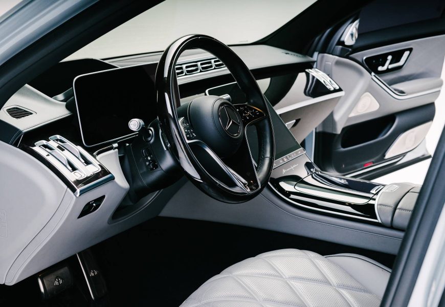Maybach S680 cockpit from the passenger side with the black steering wheel and white quilted seats