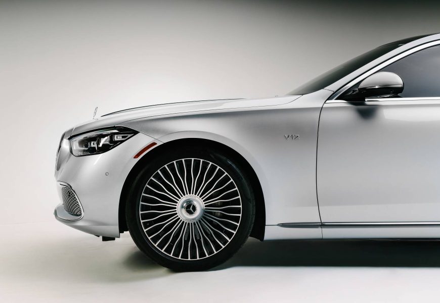 Front fender of the white Maybach S680 with the V12 badge and the chrome multi-spoke wheel