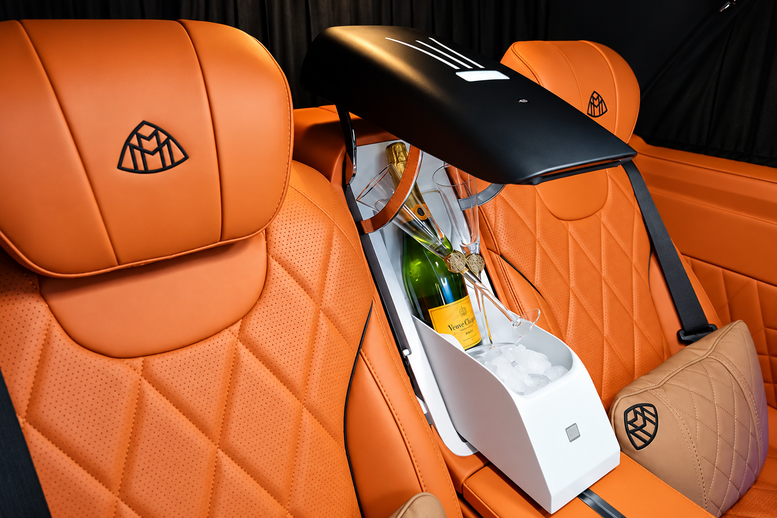 Orange quilted captain chair in the Mercedes-Benz Sprinter rental with a champagne bottle in the cooler