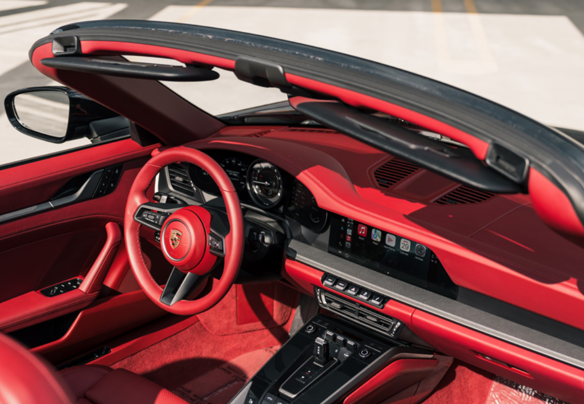 Bordeaux red steering wheel, dash and seats inside the Porsche 911 Carrera Cabriolet with the PDK toggle