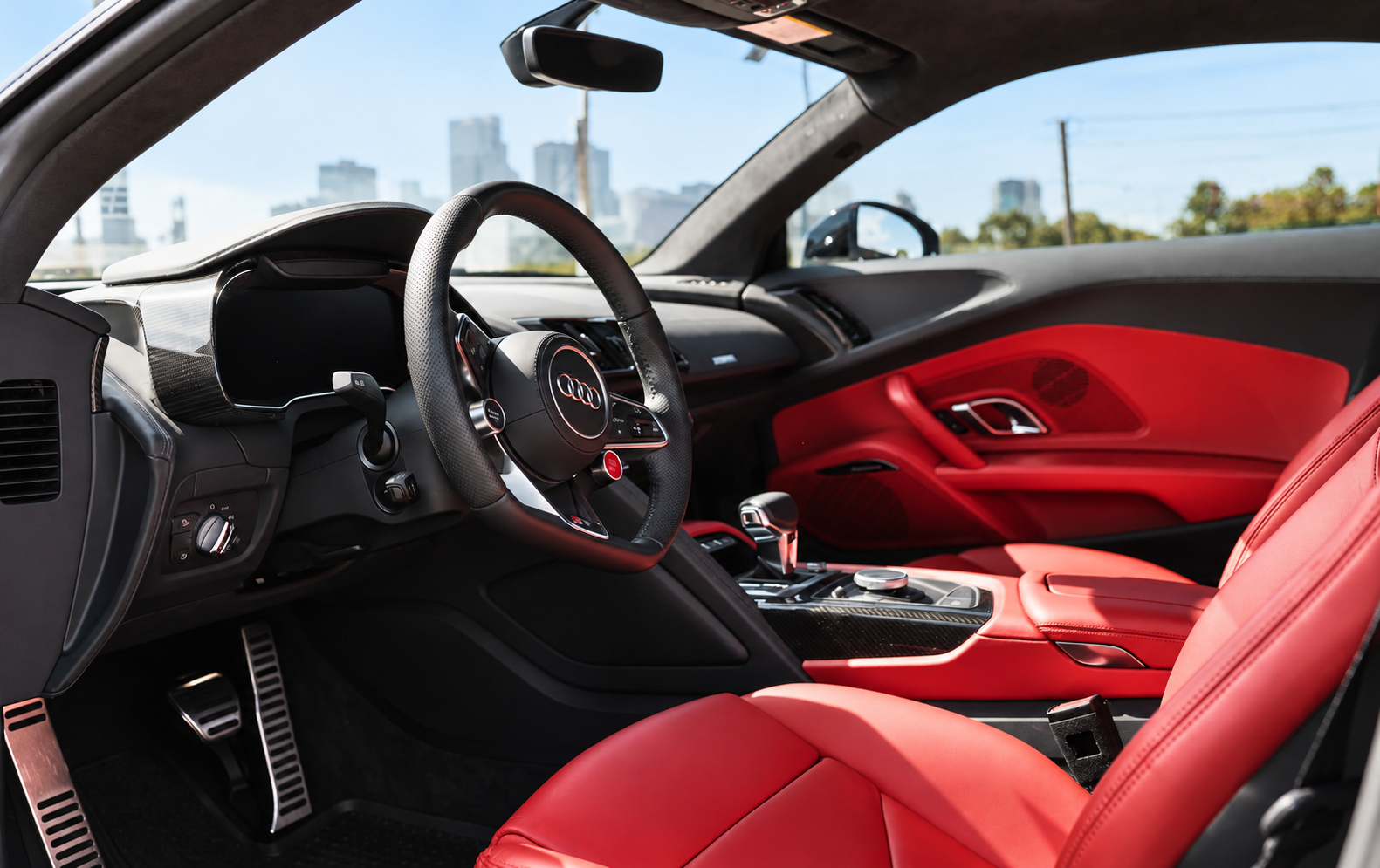 Audi R8 V10 Coupe interior from the passenger side, red leather seats and door panels with the Virtual Cockpit ahead