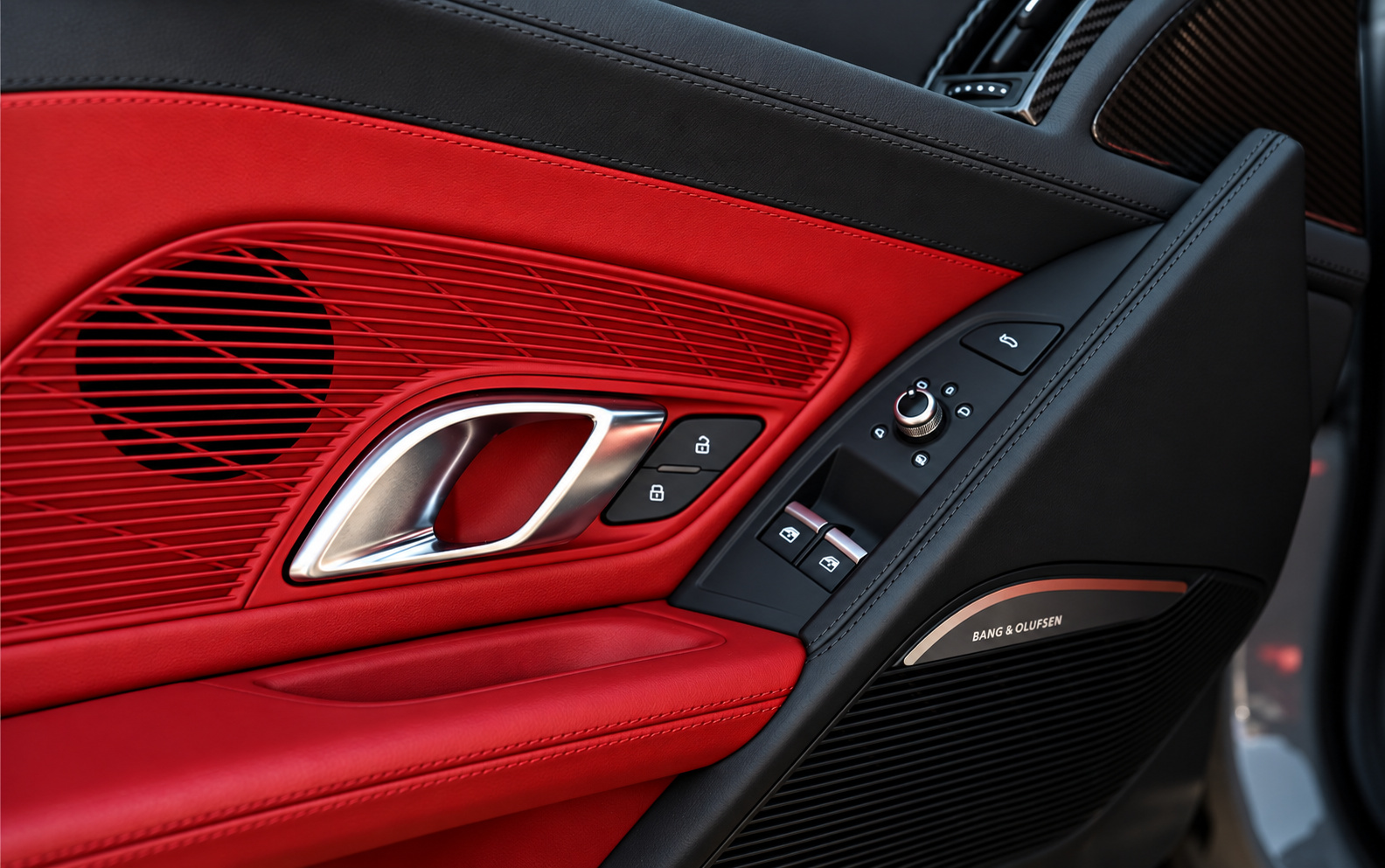 Door panel detail on the R8 V10 Coupe, red leather, carbon fiber trim and the Bang and Olufsen speaker grille