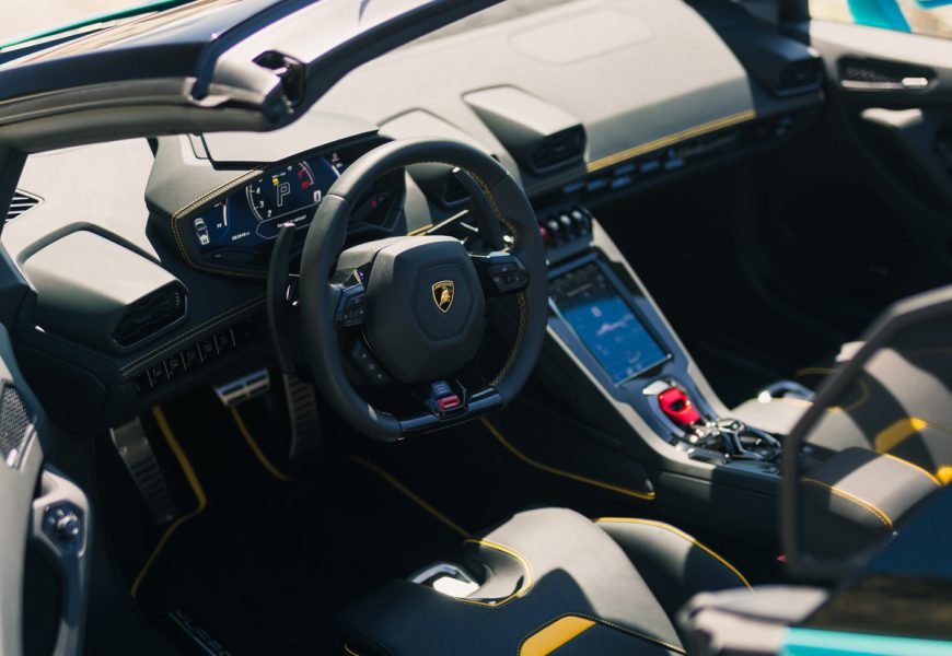 Black and yellow-stitched cabin of the Huracan Evo Spyder, steering wheel, portrait touchscreen and red start flap