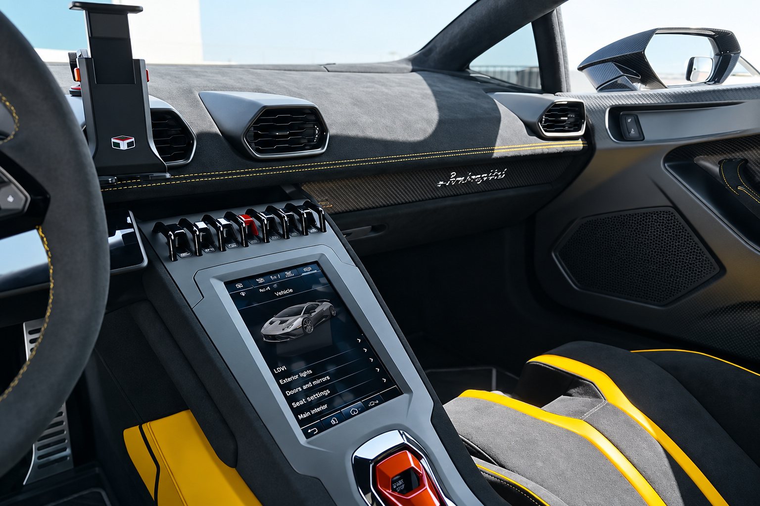 Centre console of the Huracan STO, portrait touchscreen, carbon trim, red start flap and yellow door insert