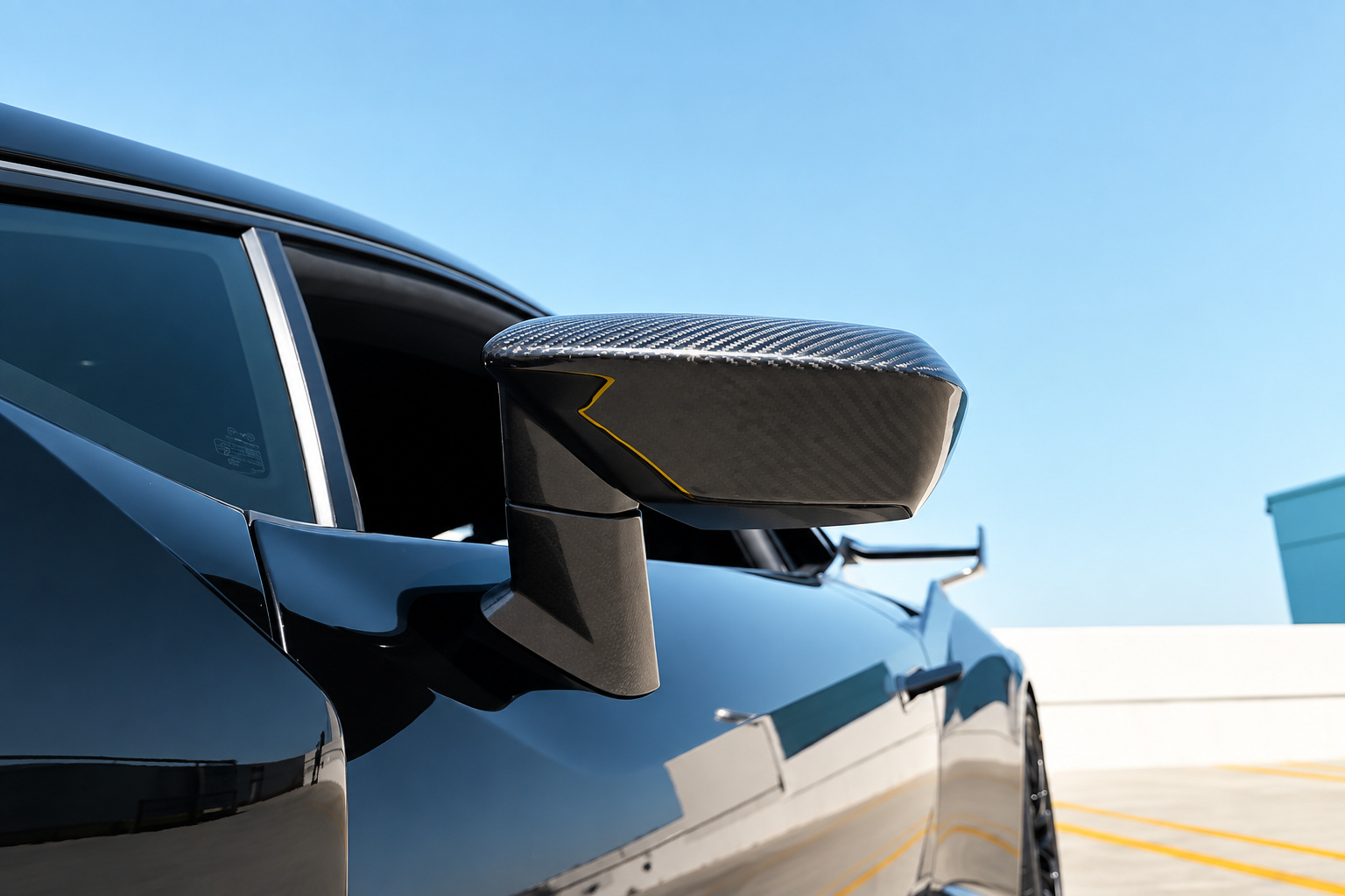 Carbon fibre mirror on the black Huracan STO door with the rear wing behind it
