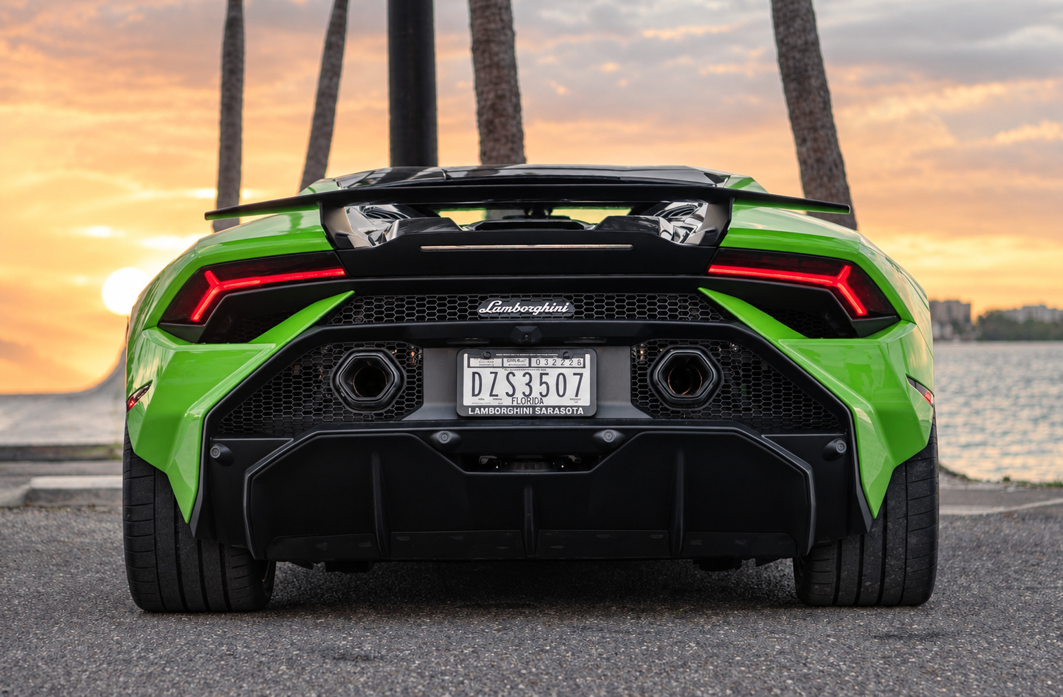 Rear view of the green Huracan Tecnica at sunset, ducktail, twin exhausts and the diffuser