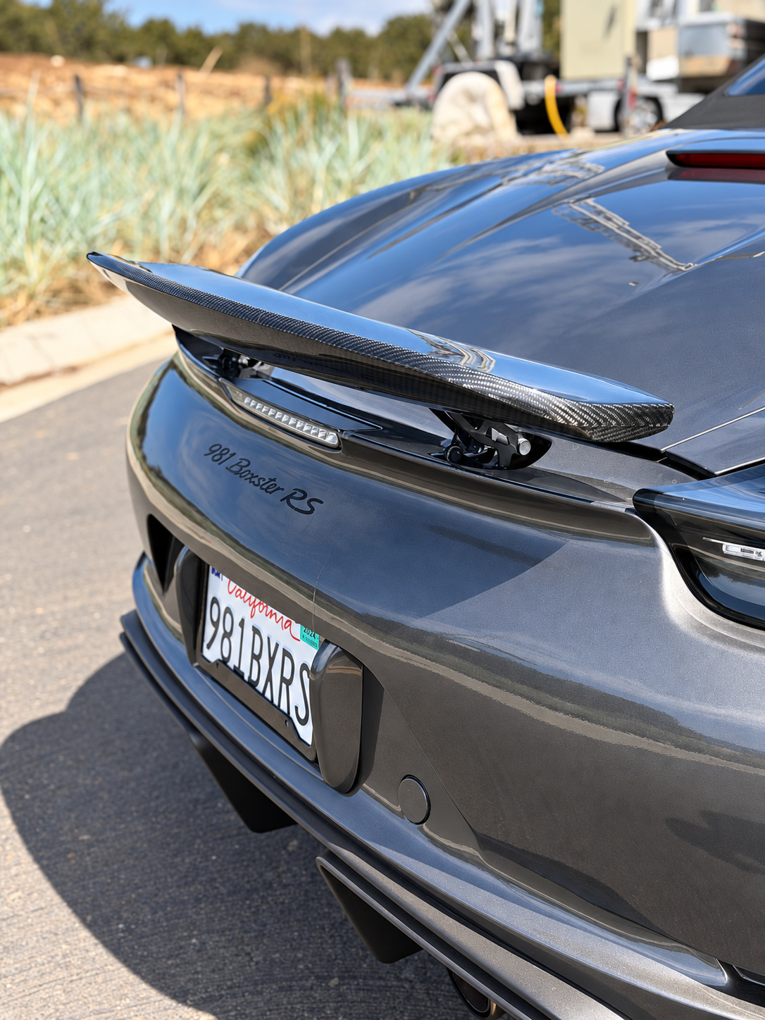 Carbon ducktail wing on the rear deck of the custom grey Porsche Boxster S, close detail