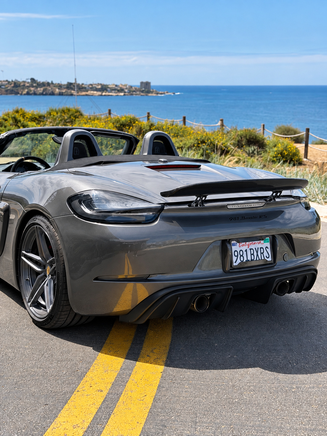 Rear view of the agate grey Porsche Boxster S, top down, on the double yellow line of the La Jolla coast road