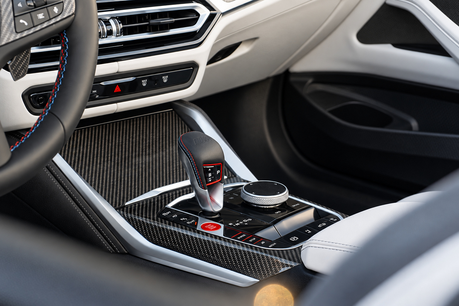 Center console of the black M4 Convertible, carbon fiber trim, red start button and ivory white leather around it