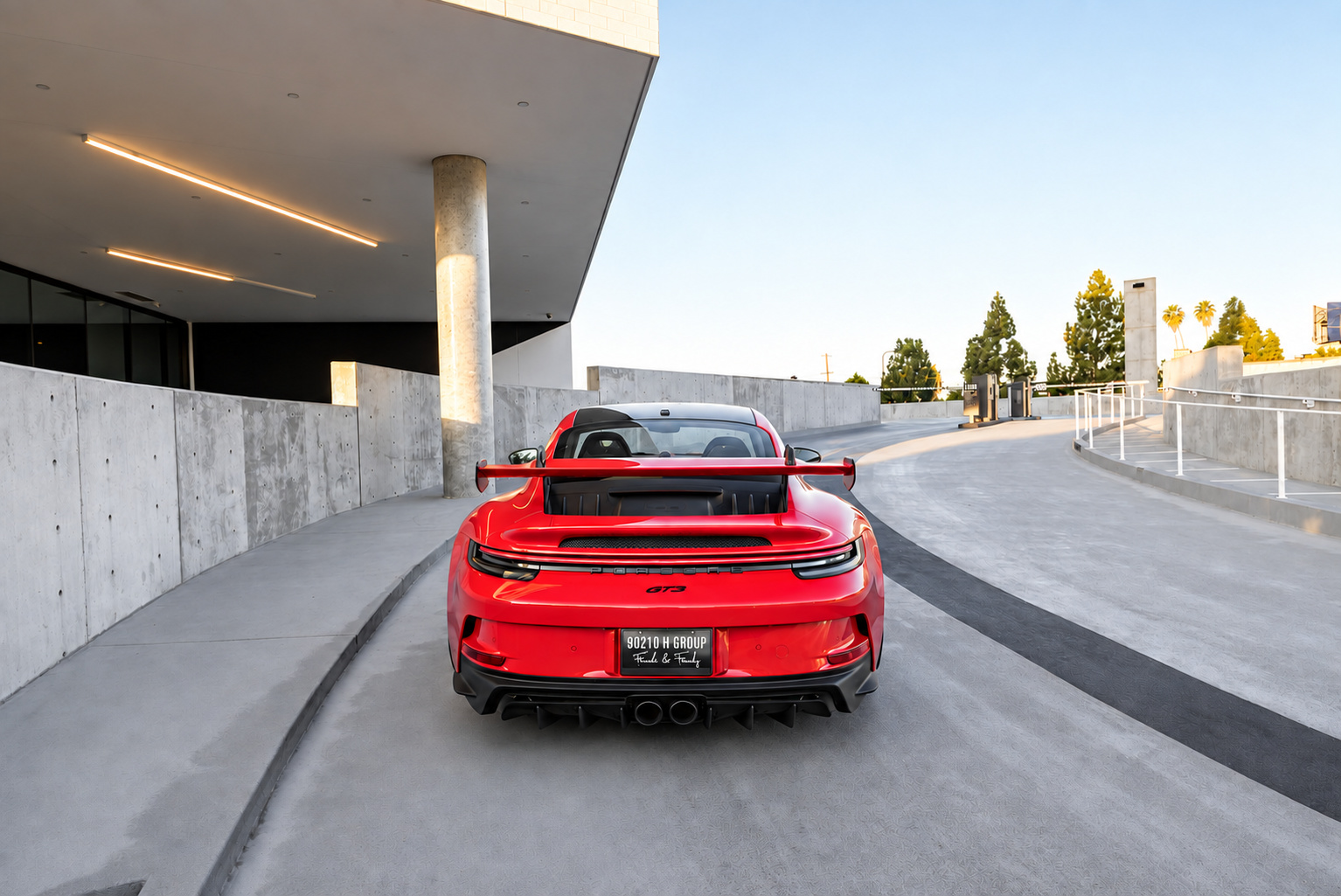 Rear view of the red Porsche 911 GT3 with the wing spanning the tail and the centre exhaust and diffuser