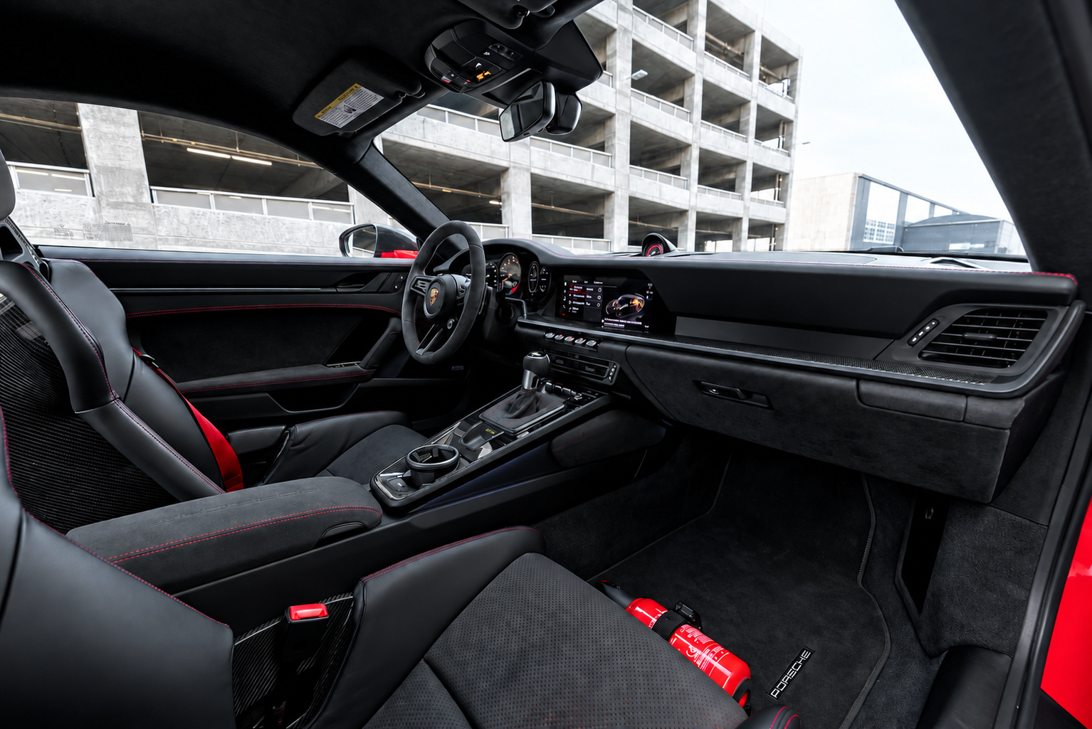 Passenger side of the Porsche 911 GT3 cabin with red stitching, suede dash and red floor mat accents
