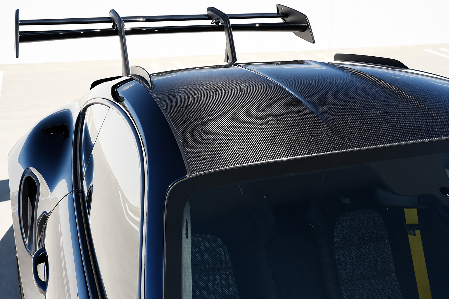 Exposed carbon roof of the Porsche 911 GT3 RS Weissach seen from above with the wing behind